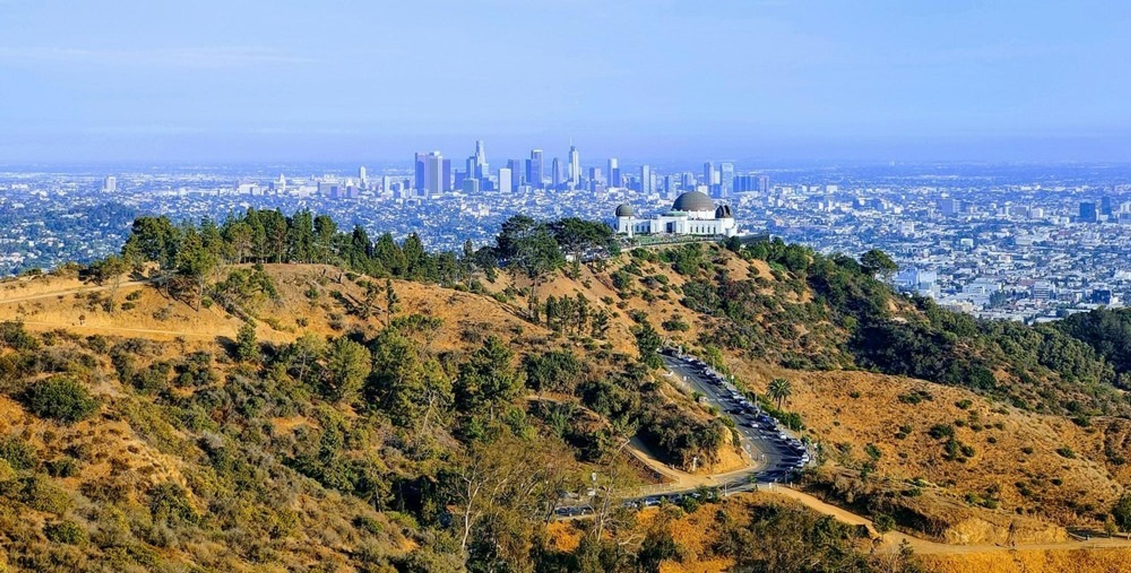 Griffith Observatory overlooks the sprawling cityscape of Los Angeles with its iconic skyline in the background.