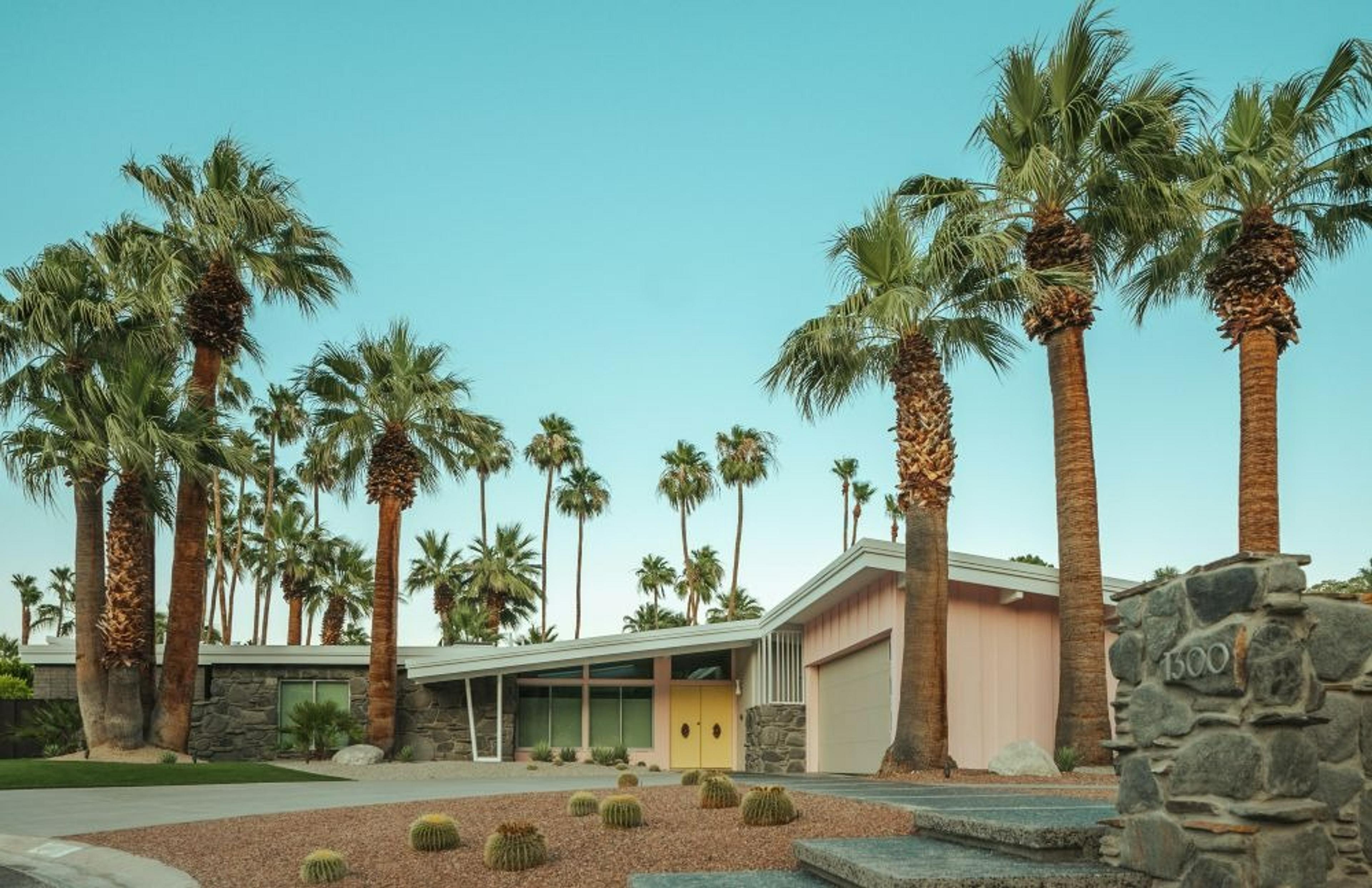 A mid-century modern house surrounded by palm trees in Palm Springs, California.