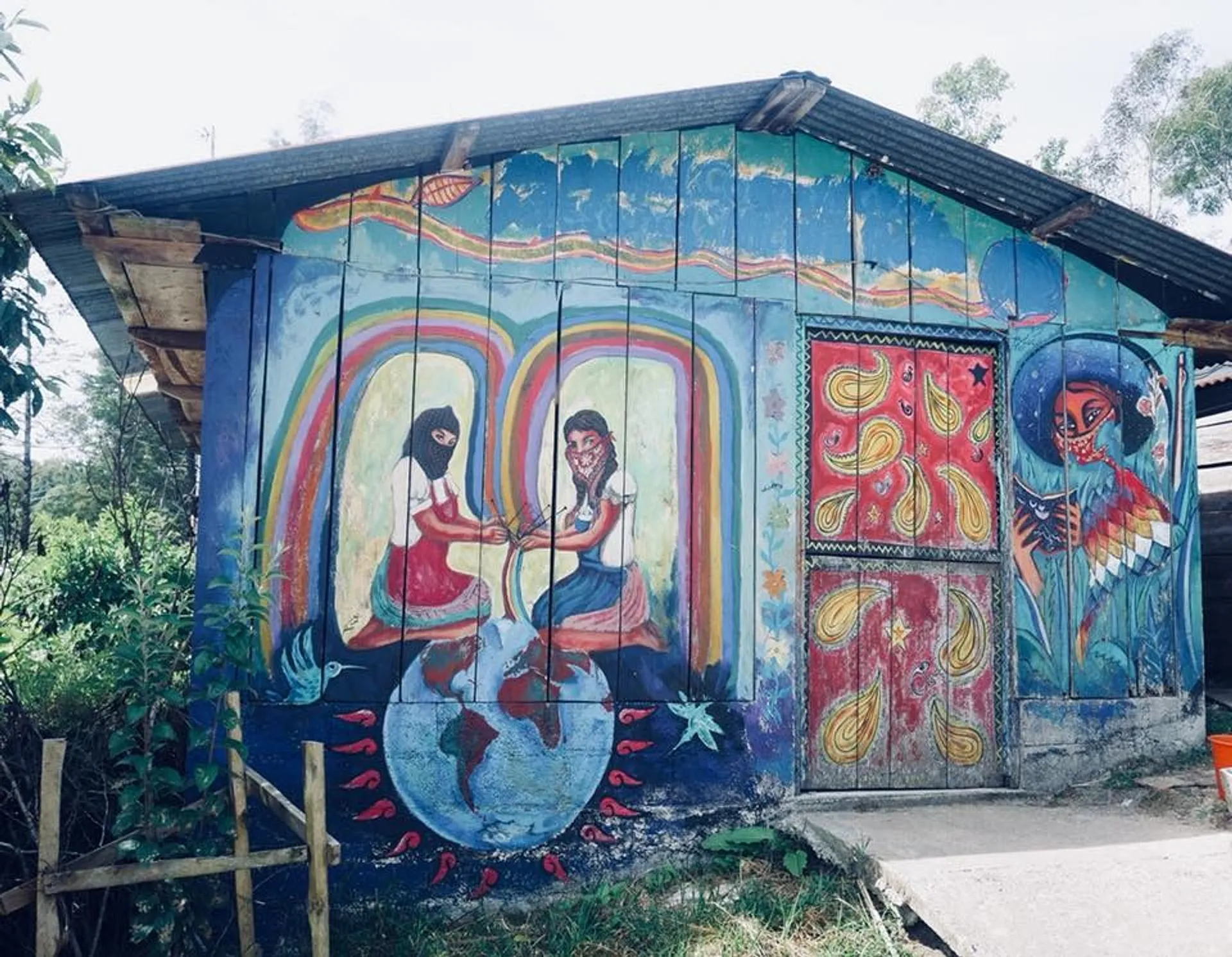 A vibrant mural covers a building in Chiapas, Mexico, depicting indigenous and revolutionary themes with colorful imagery and cultural symbolism.