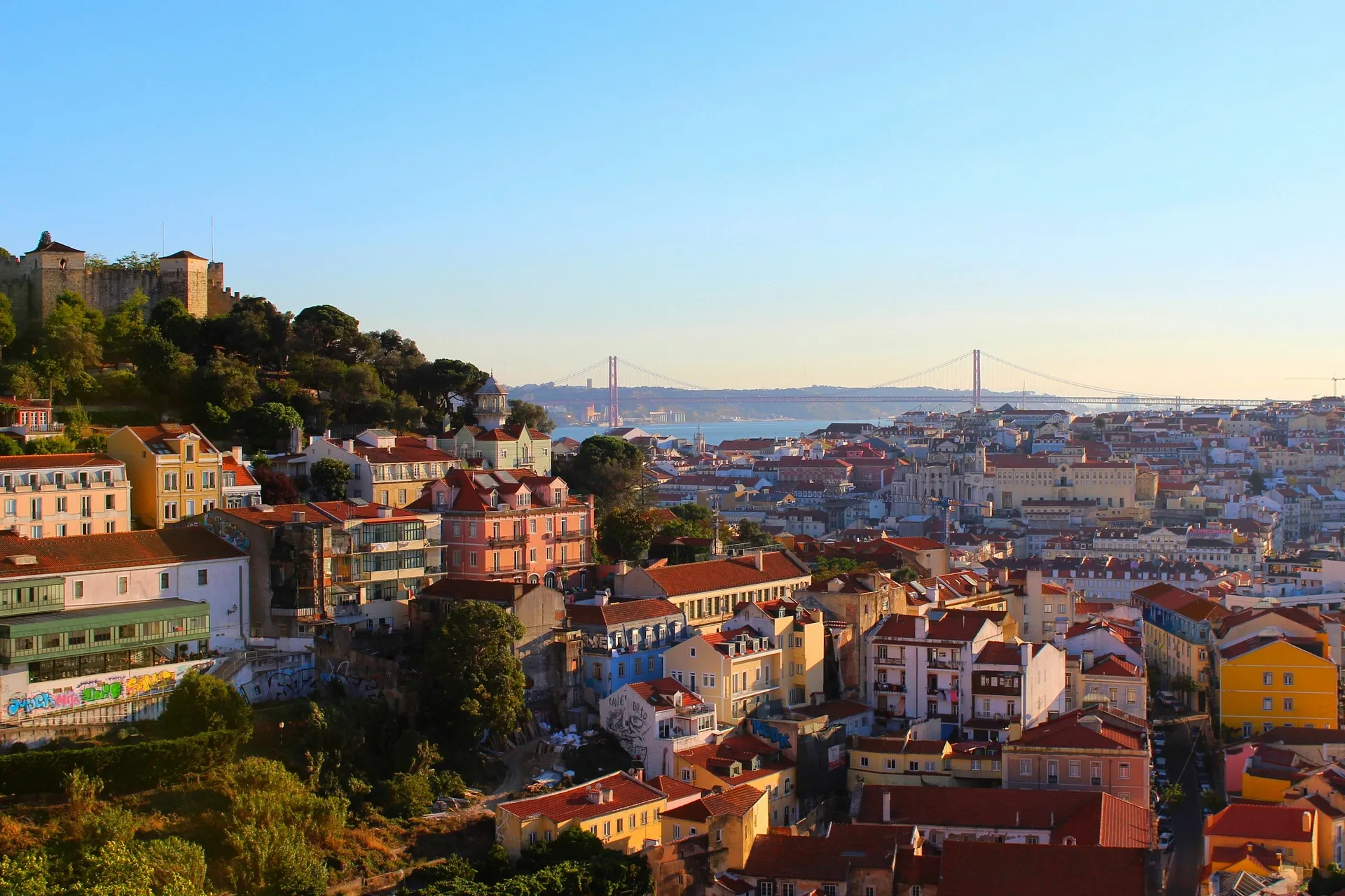 A vibrant view of Lisbon, Portugal, with the iconic 25 de Abril Bridge in the background.