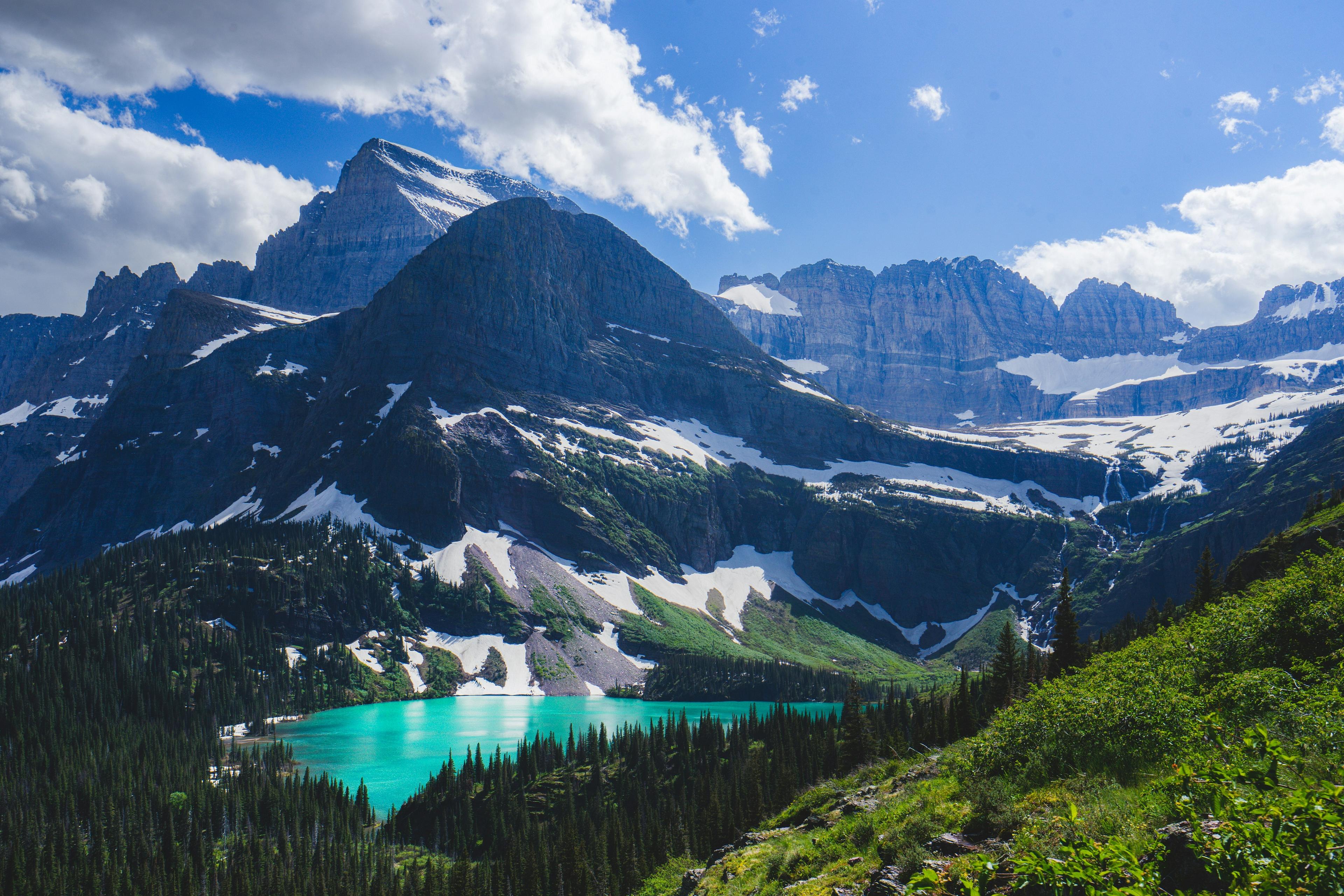 Crystalline Grinnell Lake lies nestled among the rugged, snow-capped peaks of Glacier National Park, Montana.