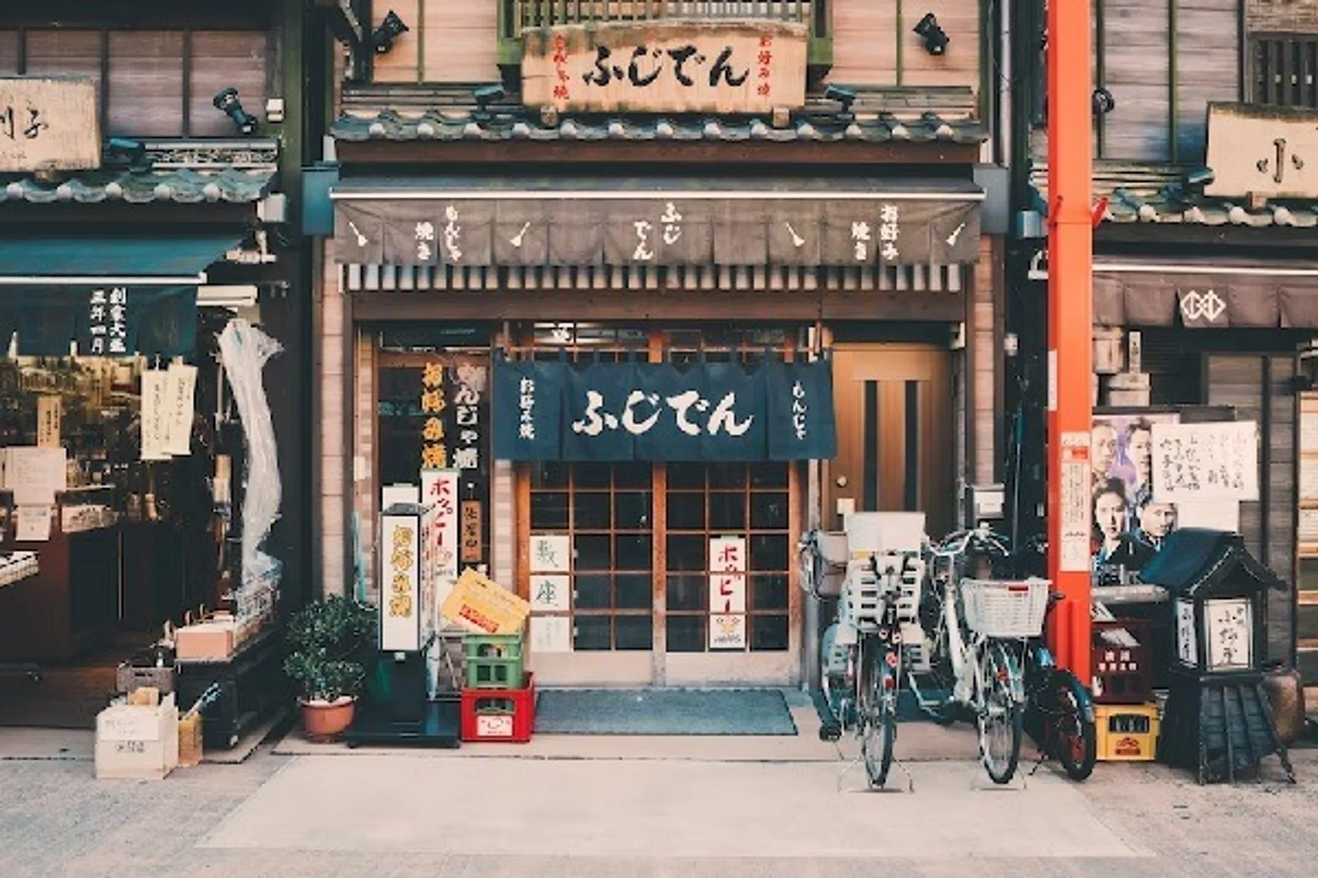 A shopfront featuring Japanese signs and three bicycles parked out front