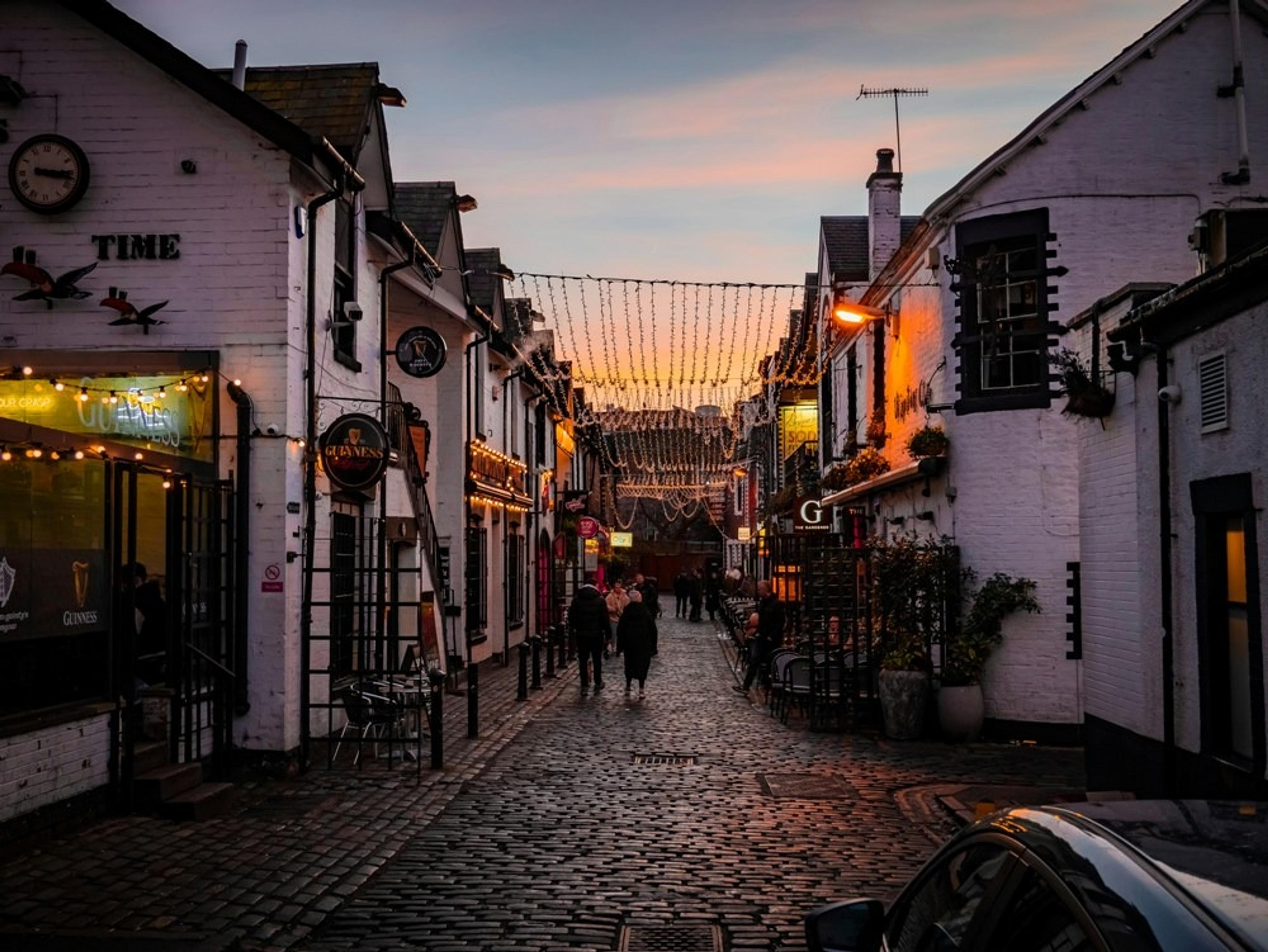 Sunset over white buildings and fairy lights on Ashton Lane, Glasgow