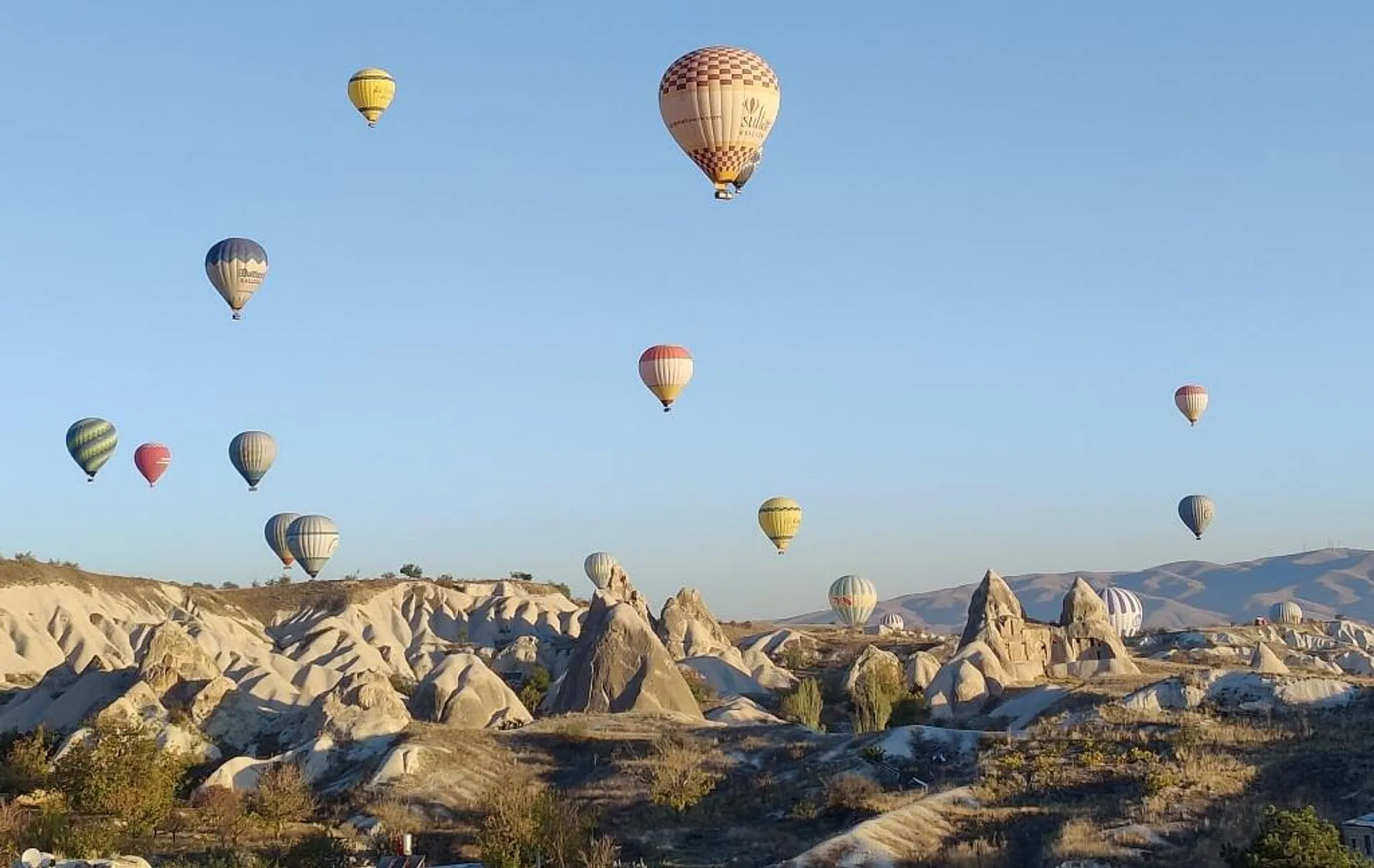 Hot air balloons rising over rock formations in Cappadocia