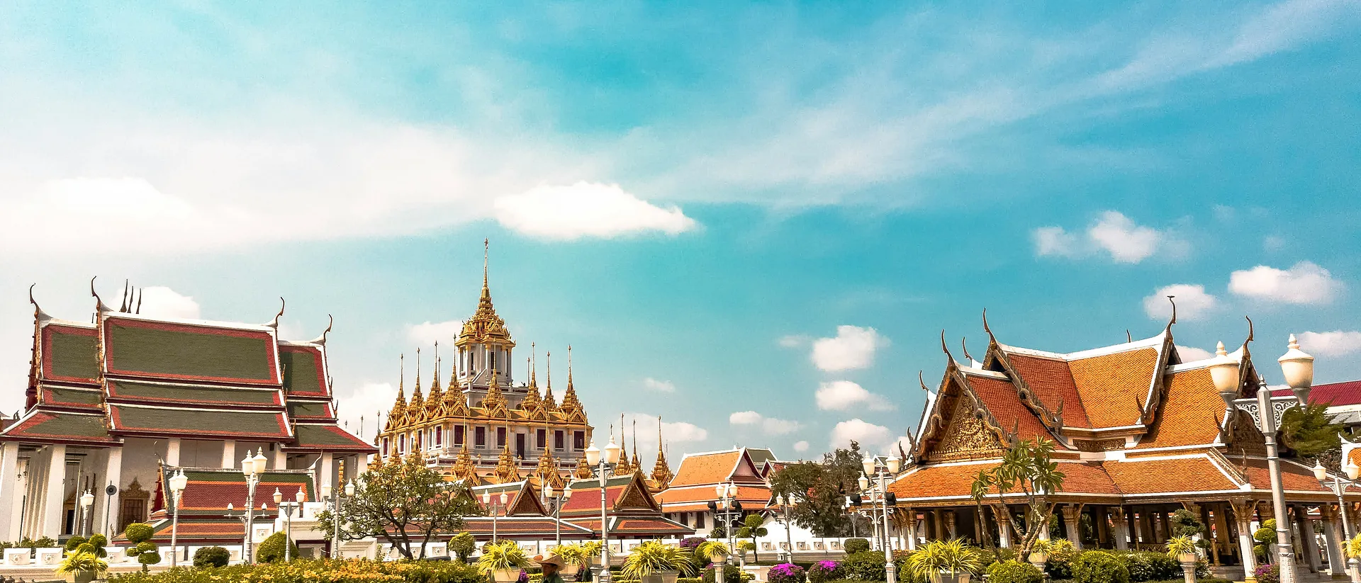 Ornate Thai architecture with intricate rooftops and spires fills the scene in Bangkok.