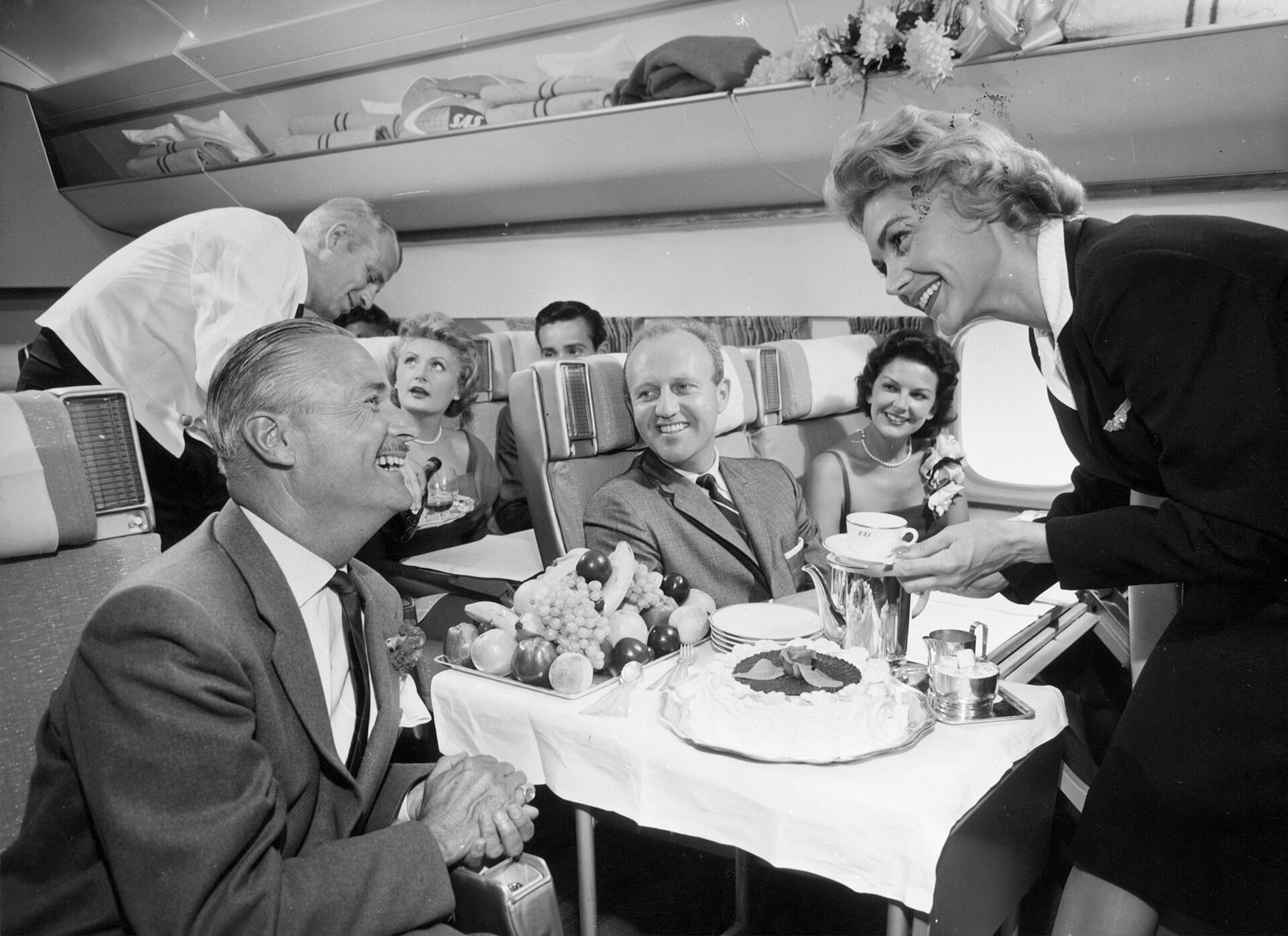Passengers enjoy a luxurious in-flight meal aboard a Scandinavian Airlines plane in the 1960s.