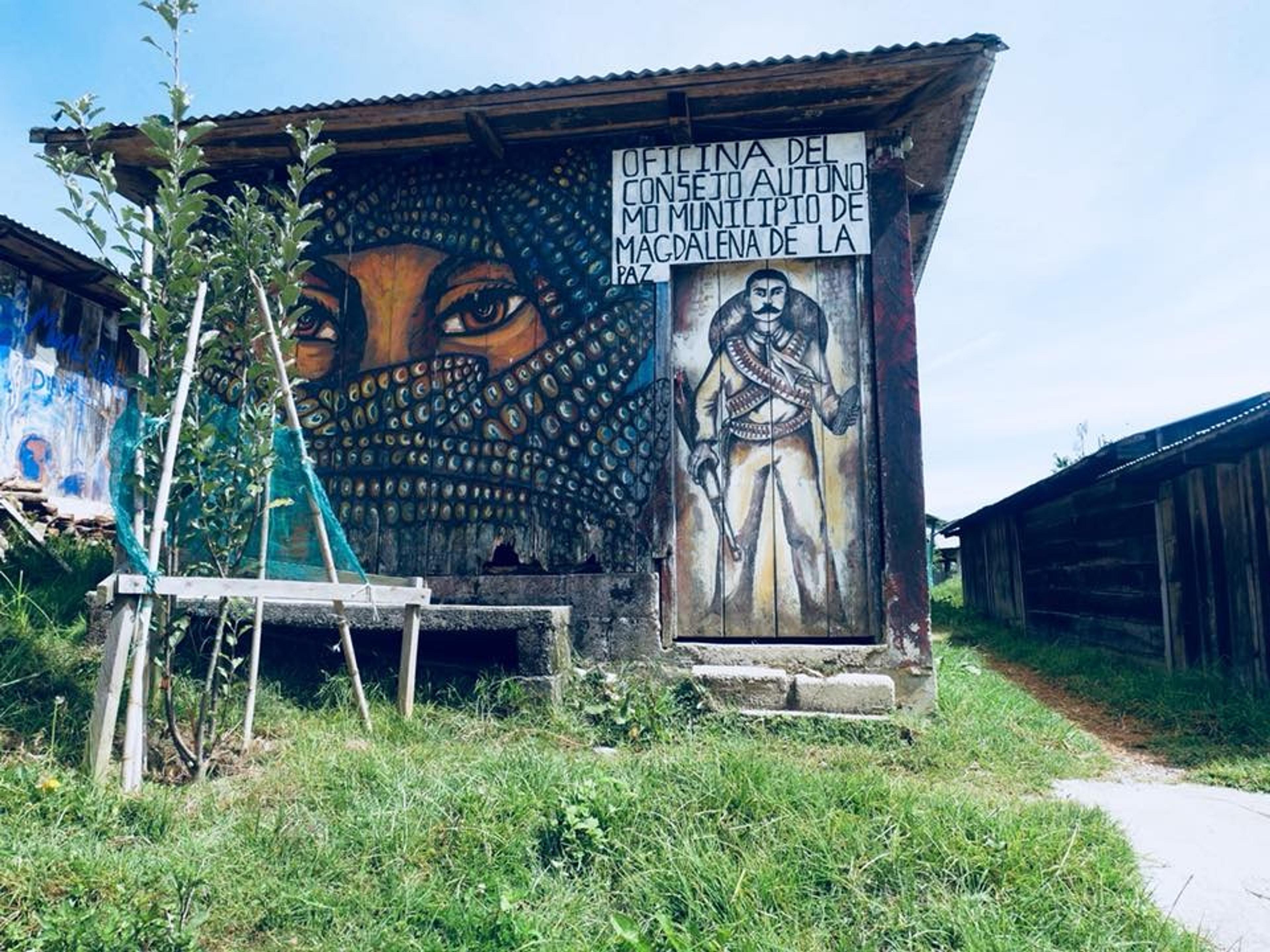 A mural-rich building in Magdalena de la Paz, featuring vibrant artwork and a sign for the "Consejo Autónomo Municipal."