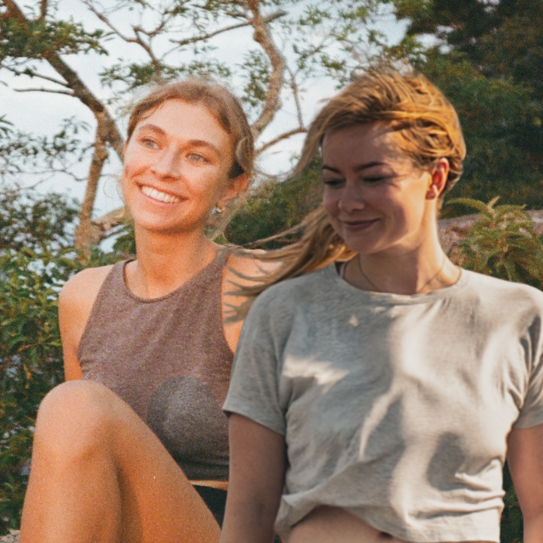 Two people stand outdoors amidst lush greenery, creating a vibrant and lively atmosphere.