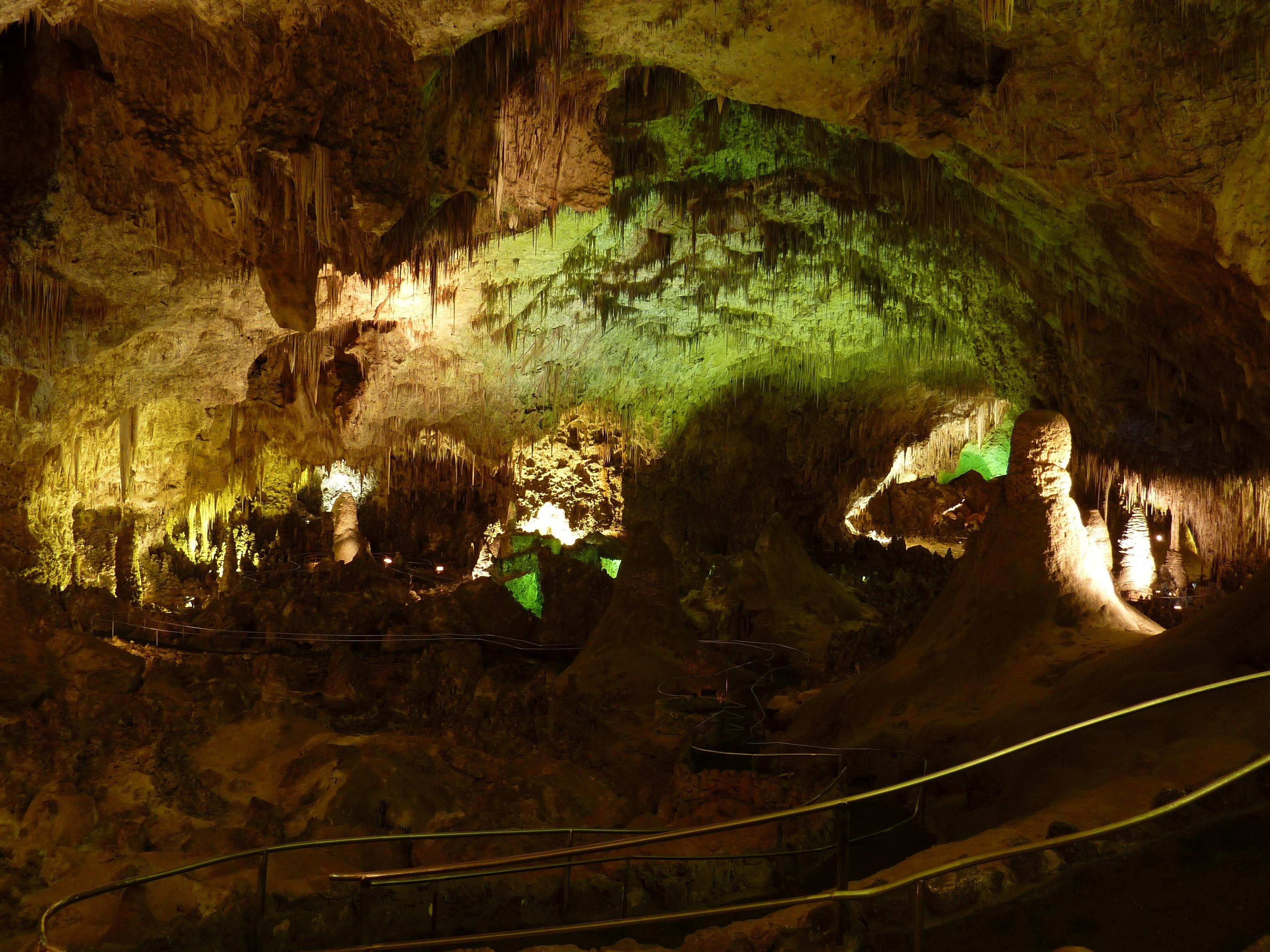 An illuminated view inside Carlsbad Caverns National Park, featuring dramatic stalagmites and stalactites.
