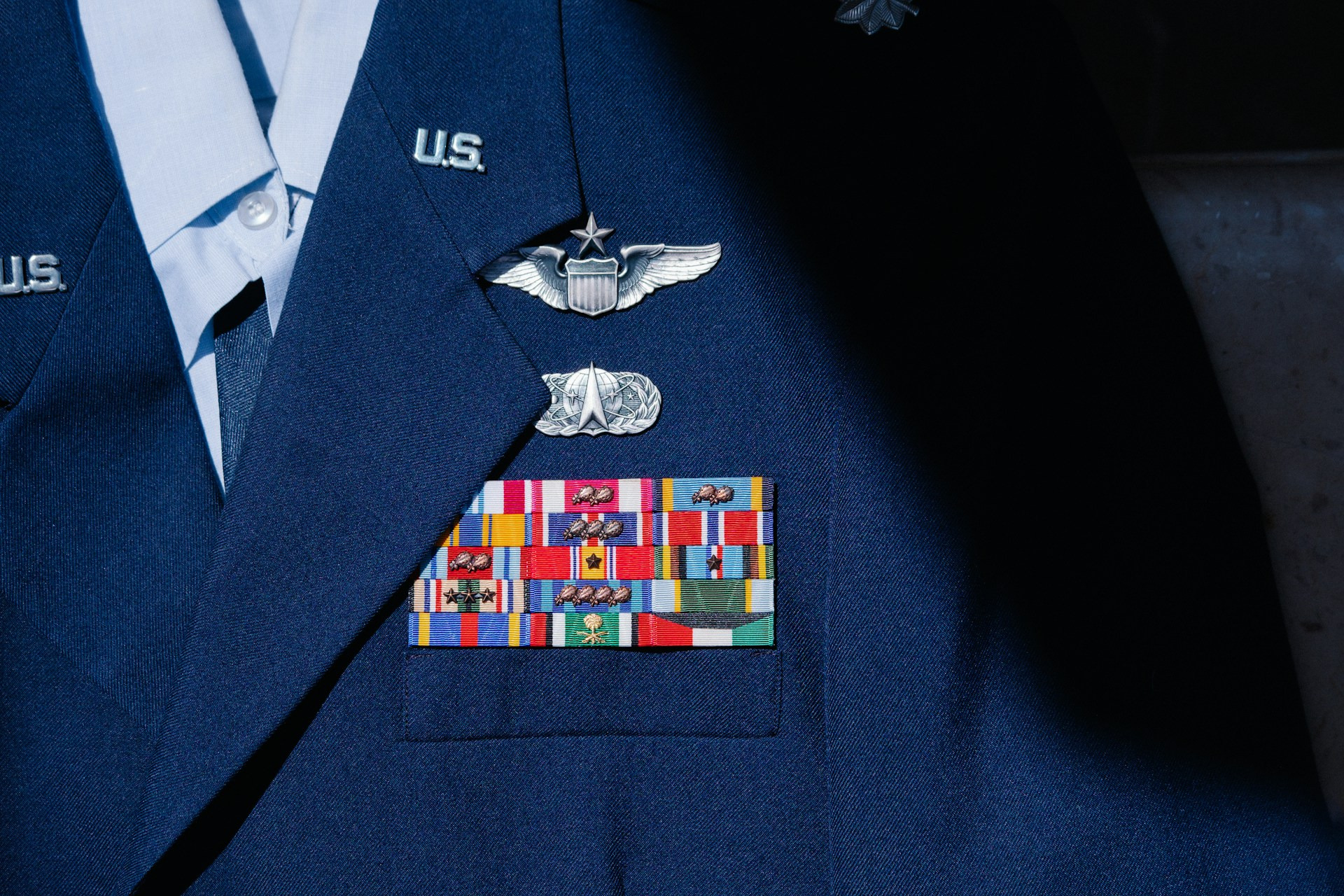 A U.S. Air Force dress uniform displays various service ribbons and insignia.