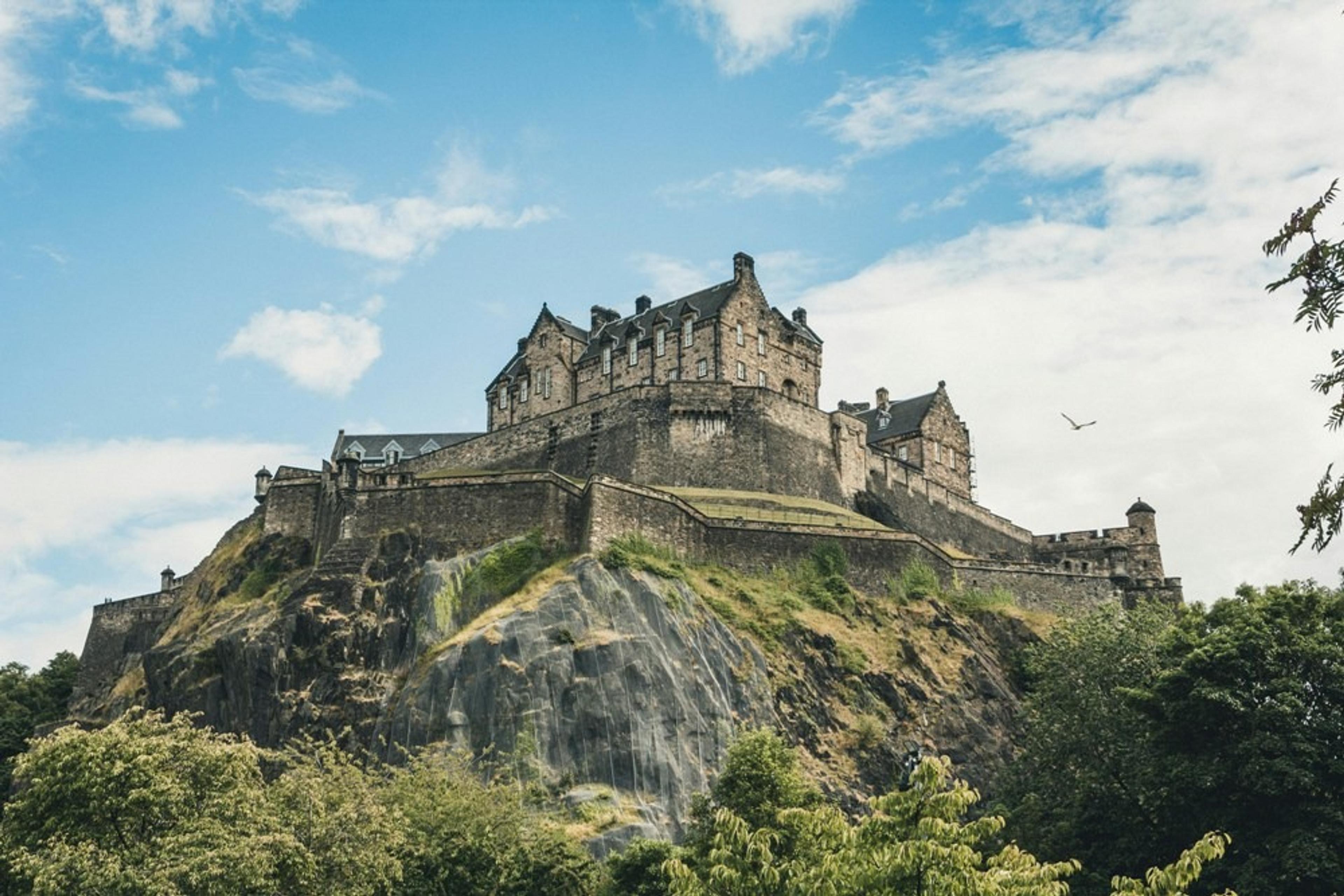 Grey concrete castle on top of a grassy hill