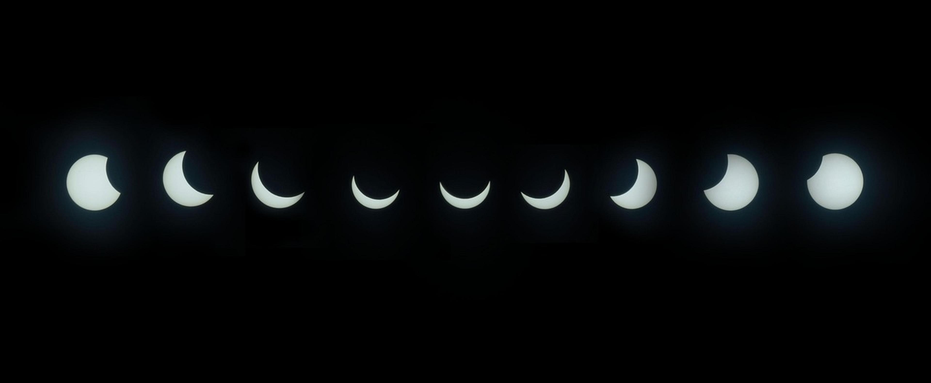 A sequence of solar eclipse phases unfolds against a dark sky, capturing the gradual occlusion of the sun.