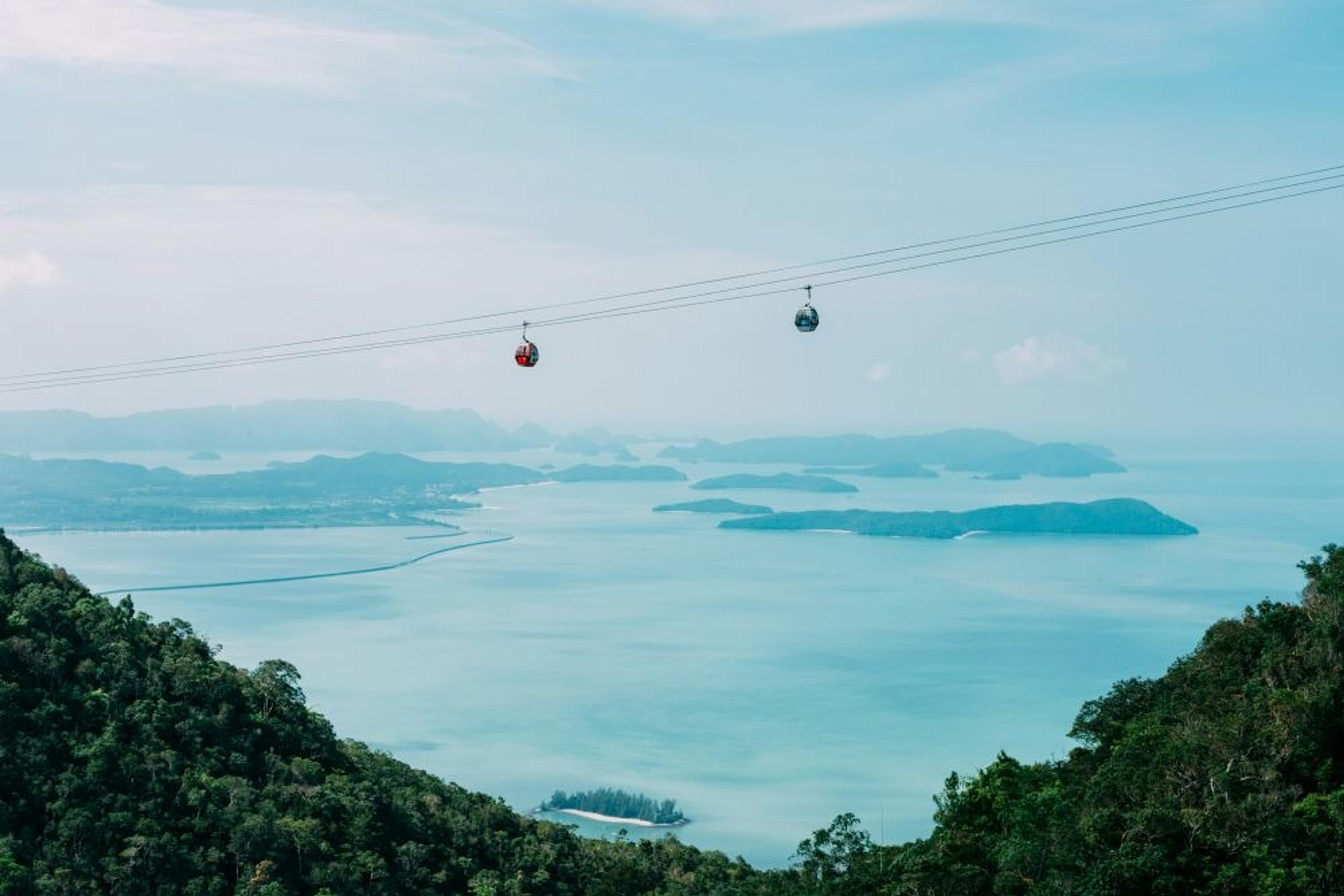 Cable cars traverse above the stunning turquoise waters and lush islands of Langkawi, Malaysia.