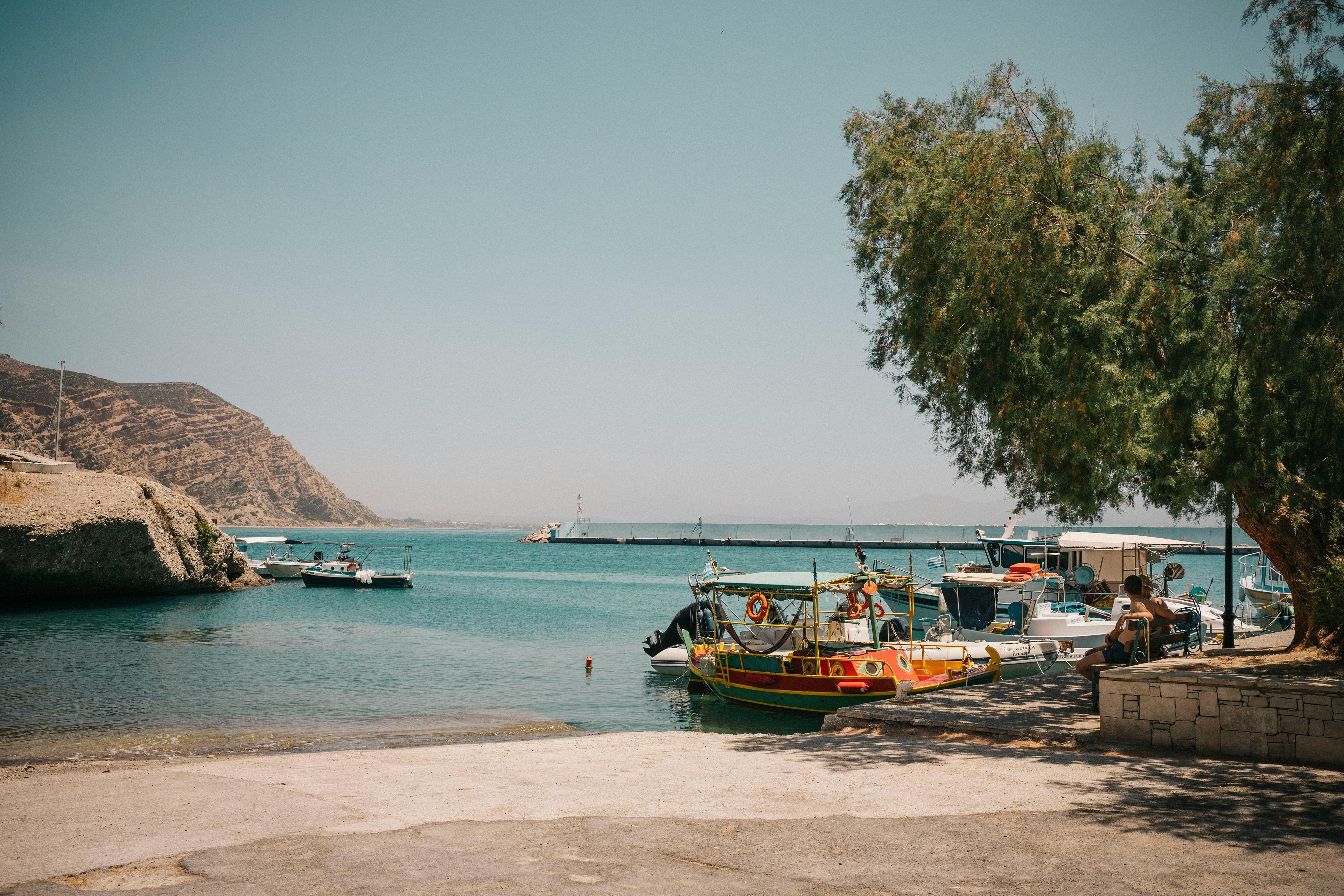Boats rest by the scenic coastline of Heraklion harbor in Crete.