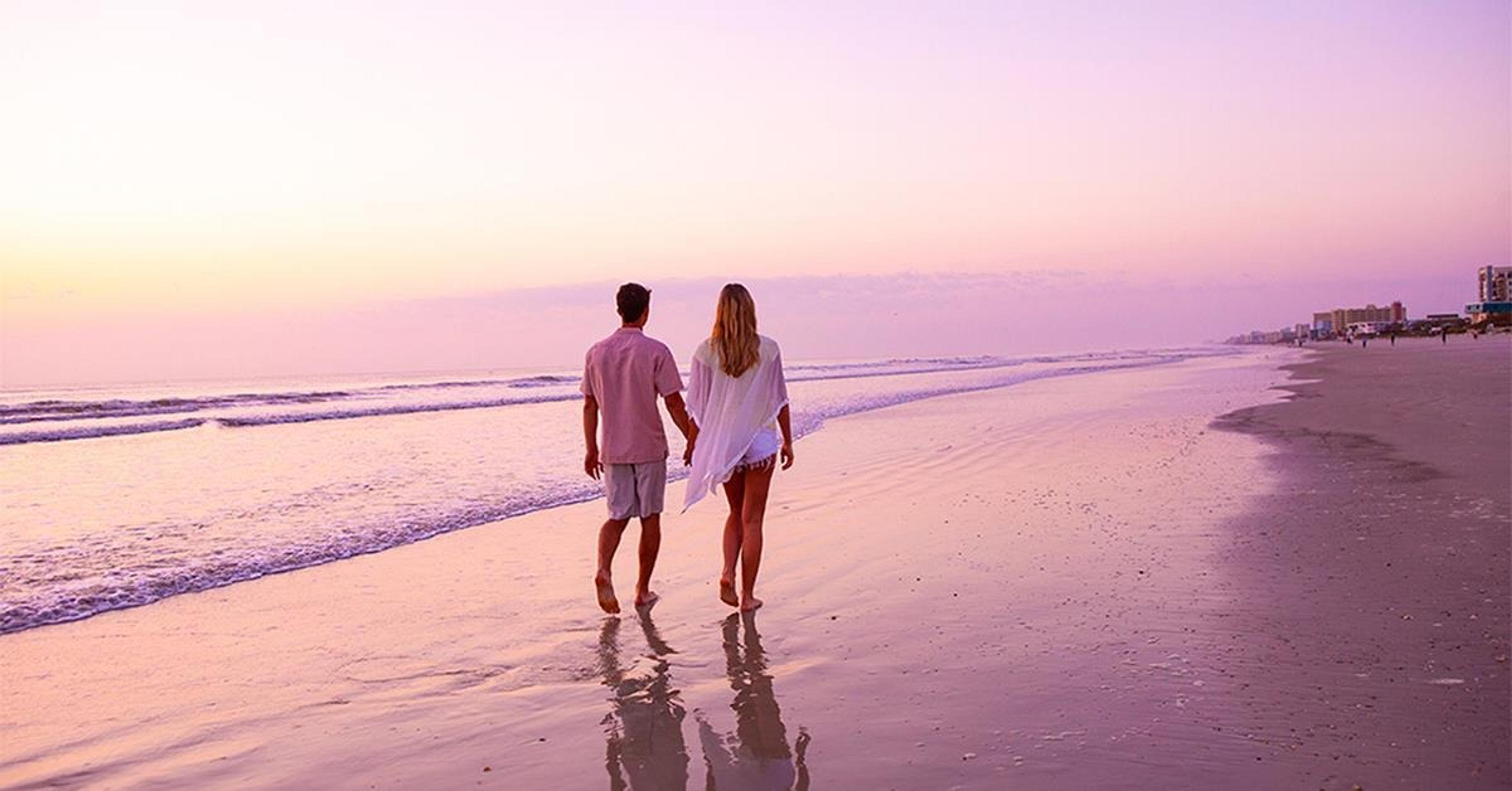 Two people holding hands on the beach