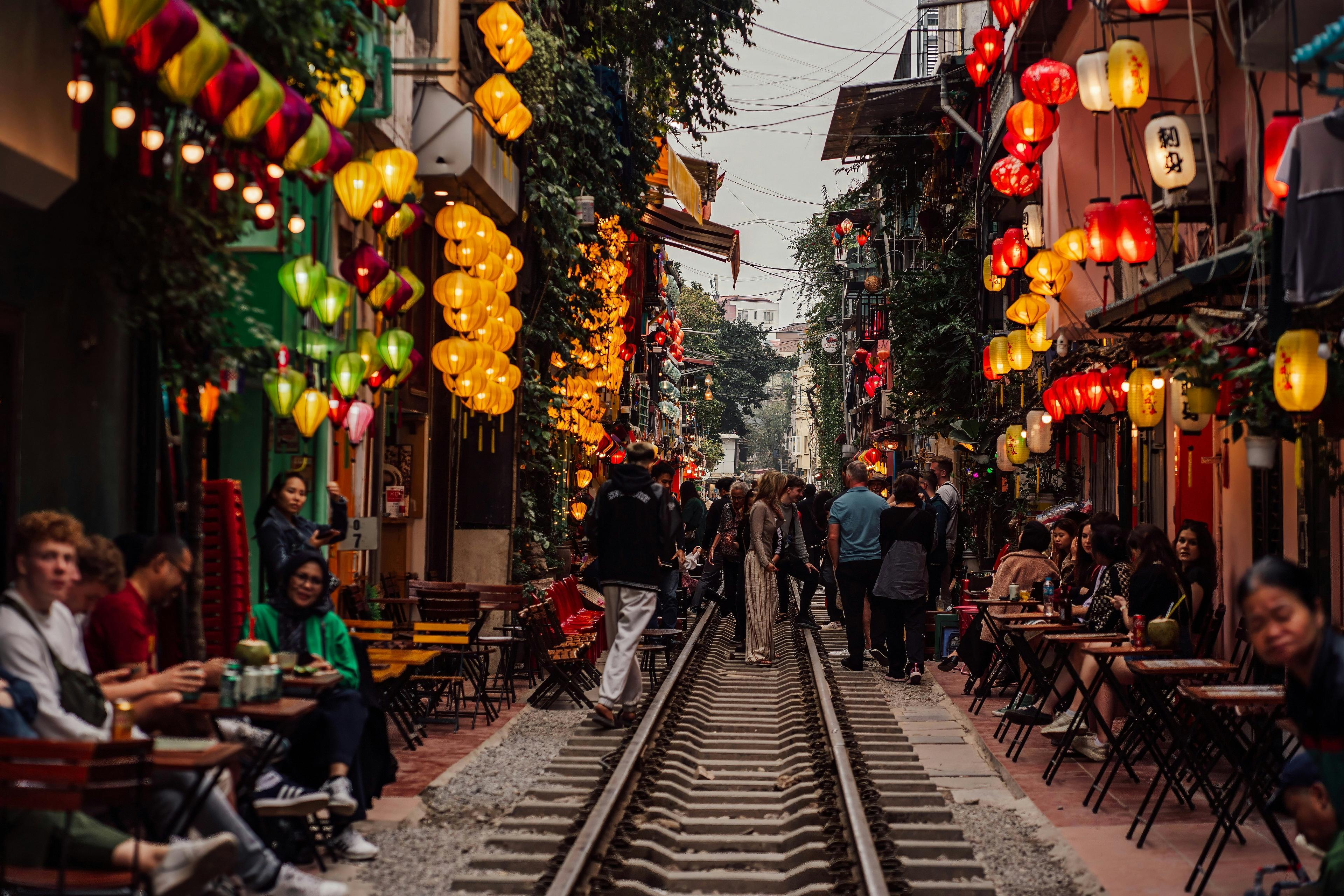 Hanoi's Train Street is lined with colorful lantern-lit cafes and bustling visitors.