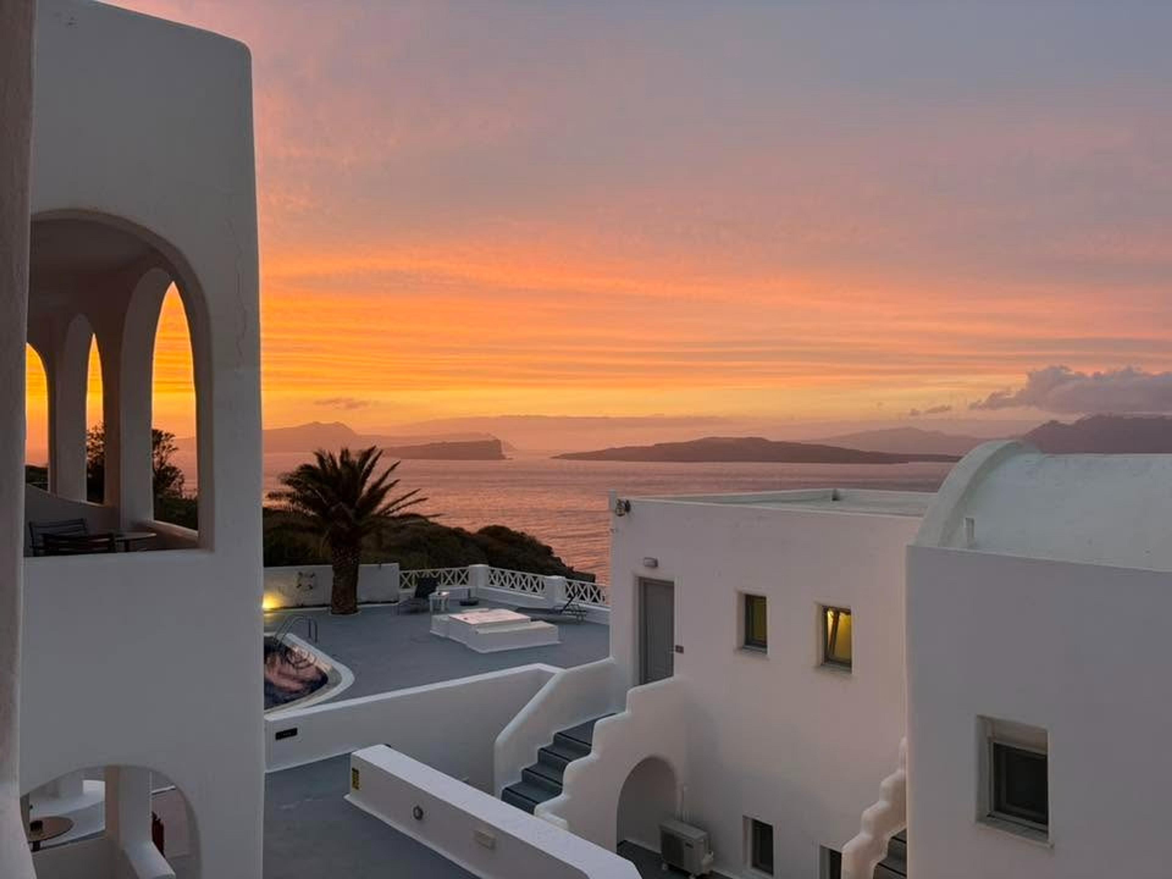 A stunning sunset view over white-washed buildings in Santorini, Greece.