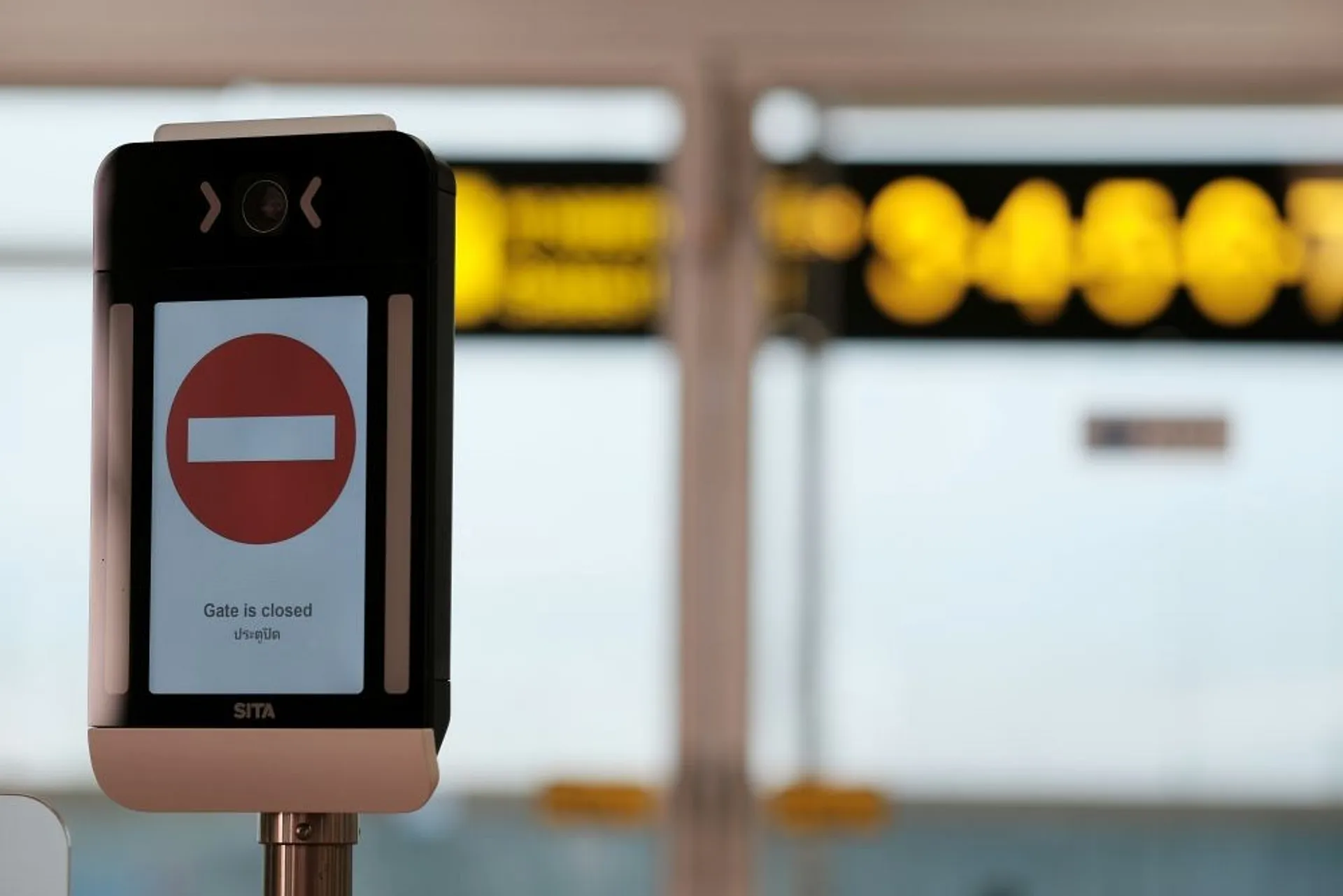 A "Gate is closed" sign at an airport terminal, possibly indicating restricted access.