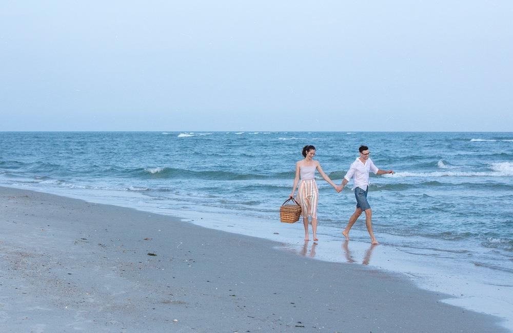 Two people holding hands on the beach