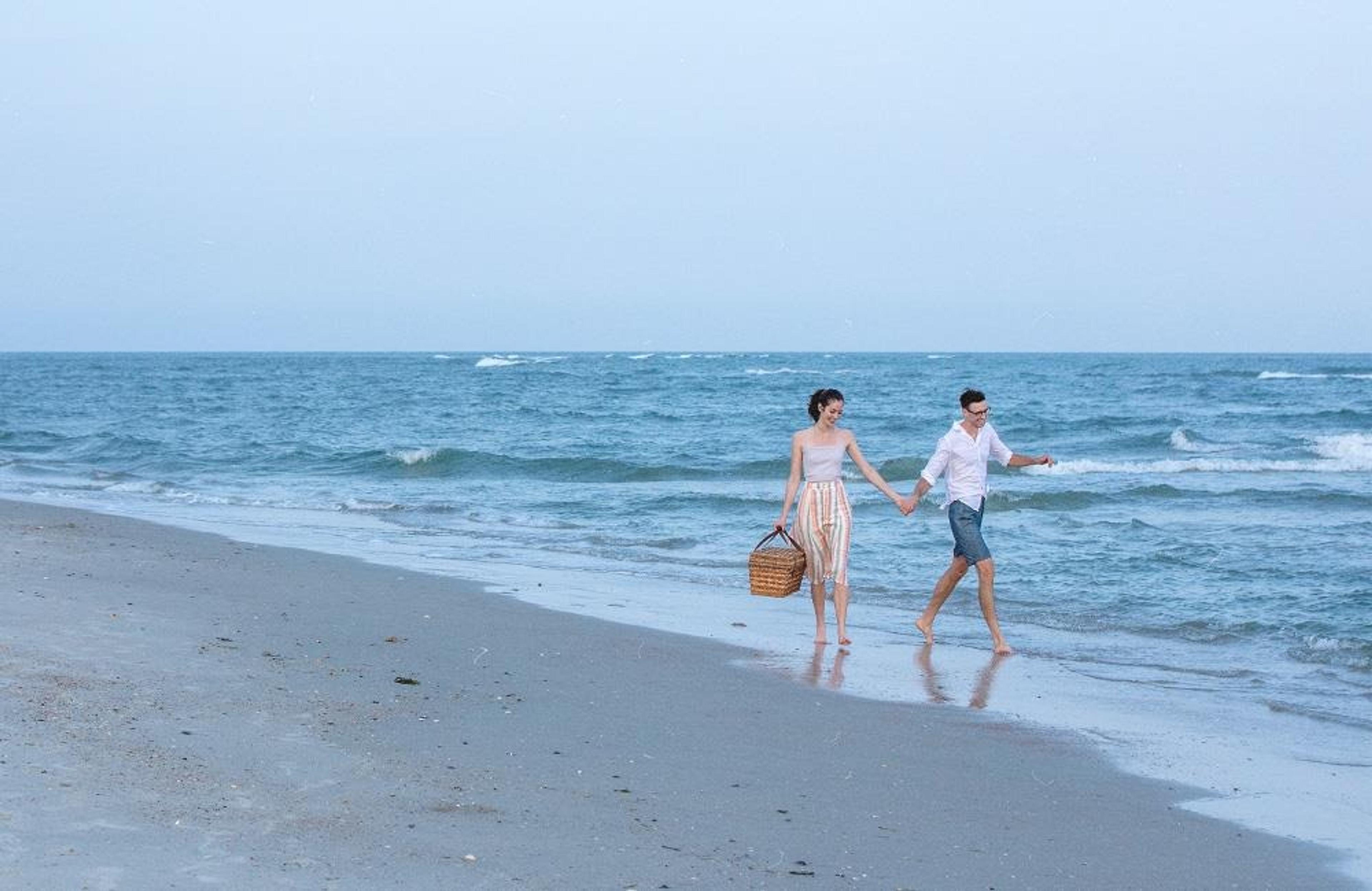 Two people holding hands on the beach