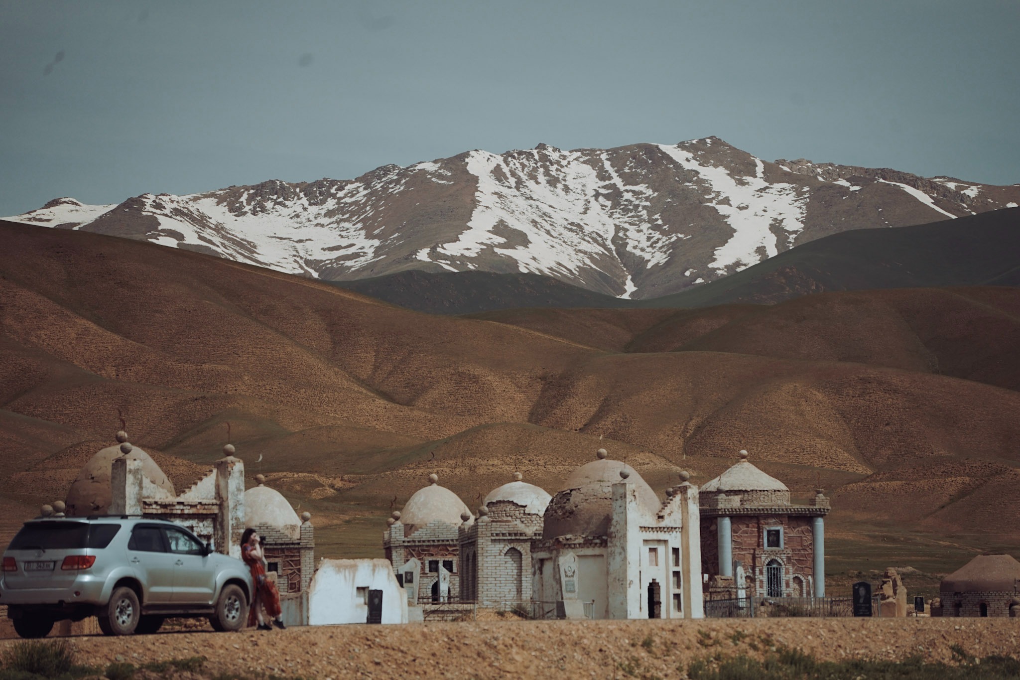 Snow-capped mountains rise in the backdrop of a remote village in Kyrgyzstan.