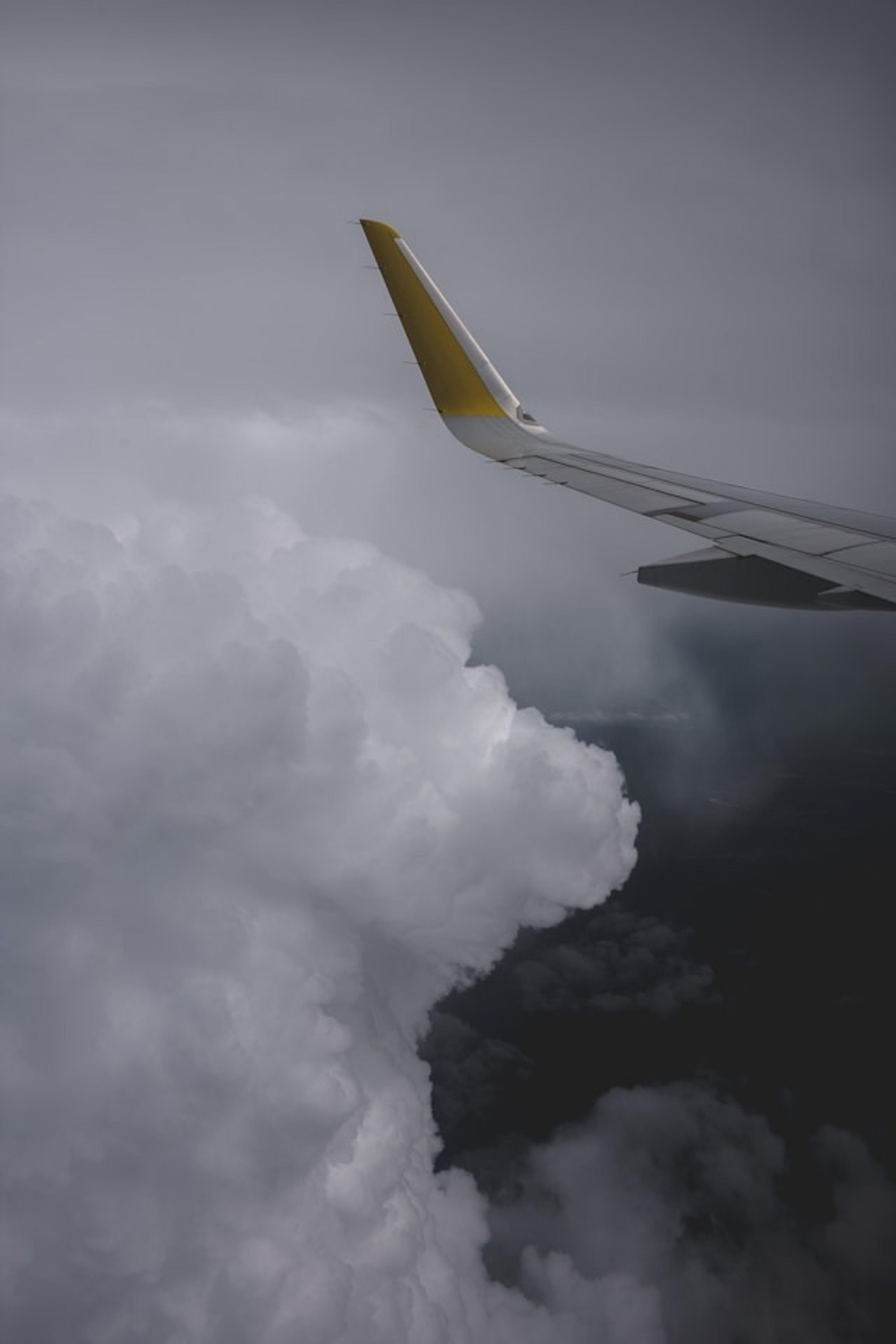 Jetliner wing soaring above a dense layer of clouds, en route to Scotland.