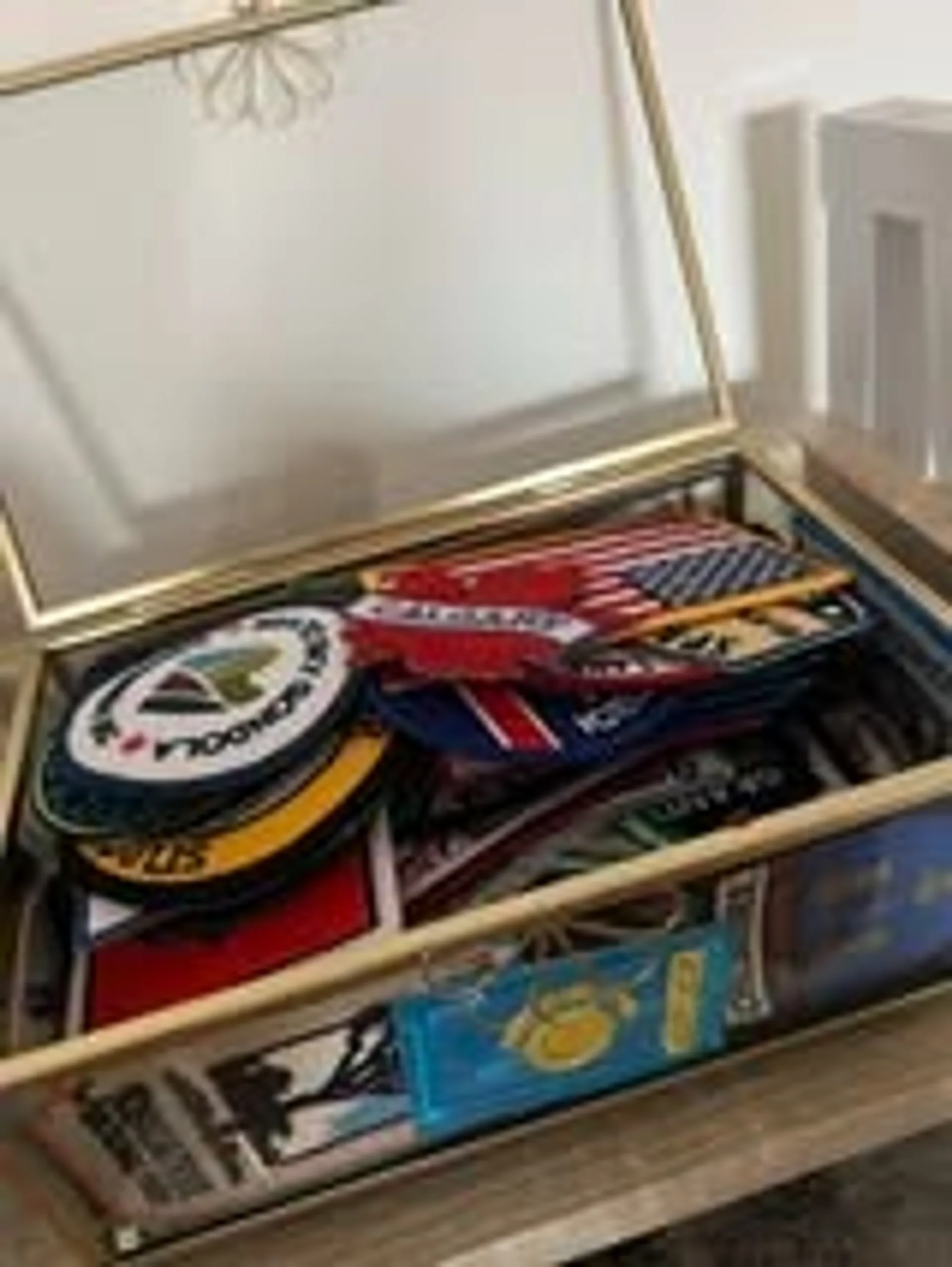 A glass box on a table holds a variety of travel patches, including one from Dulles Airport.