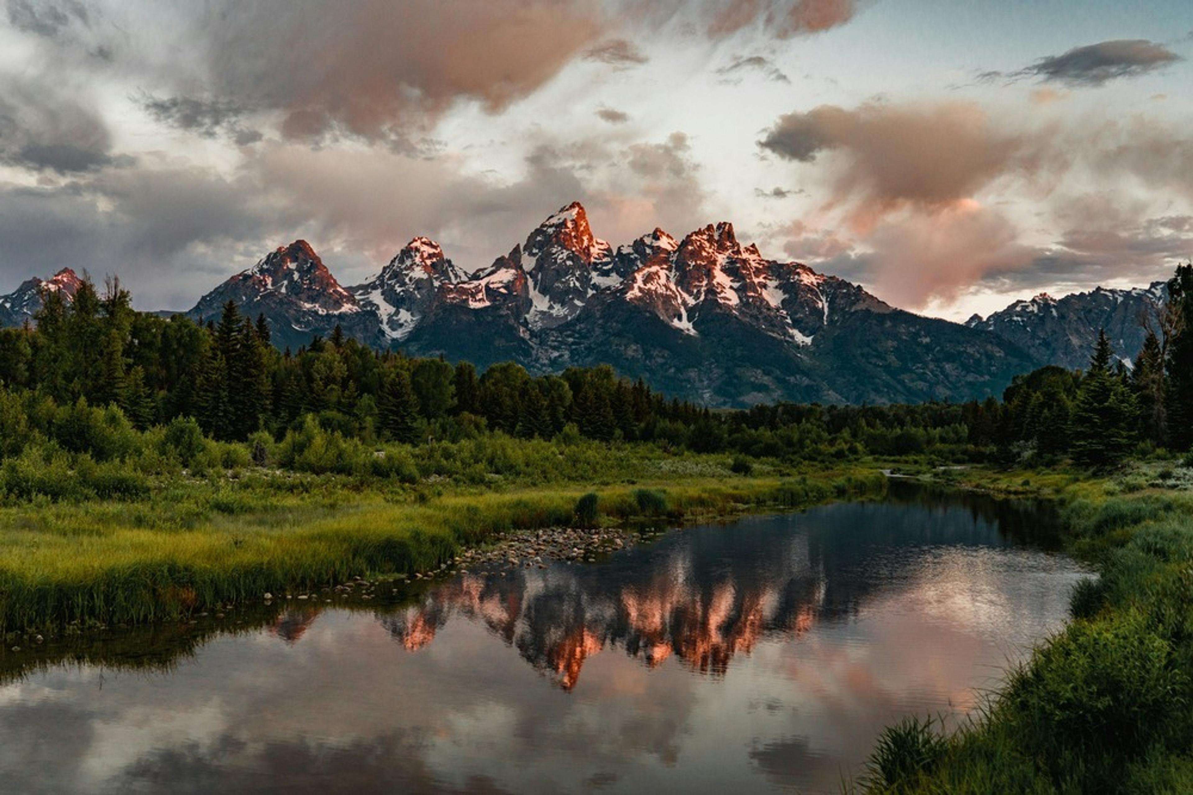 Majestic views of the Grand Teton mountains reflect in the calm waters of Schwabacher Landing in Grand Teton National Park.
