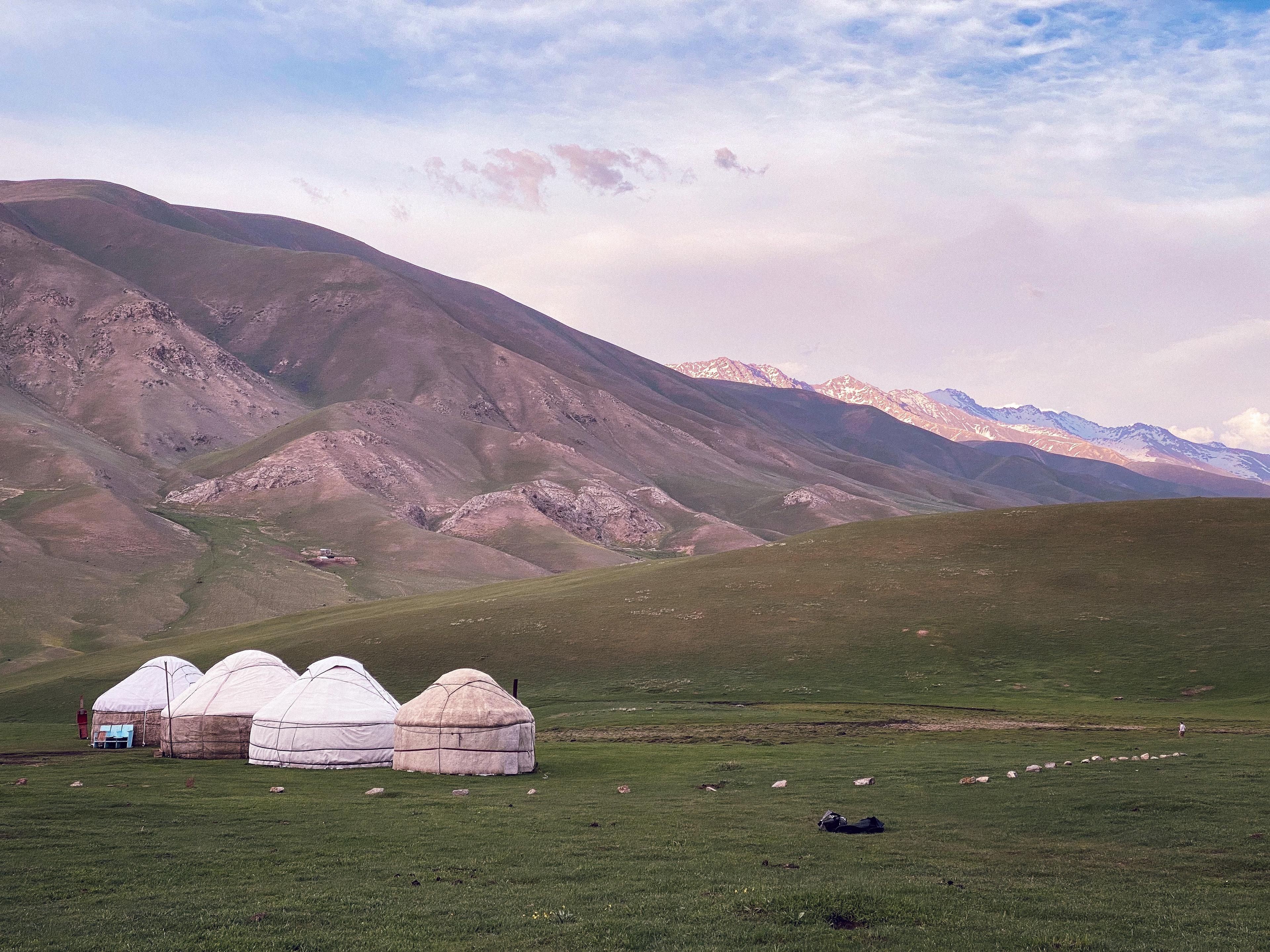 Yurts nestled in the grassy valleys beneath the Tien Shan mountains in Kyrgyzstan.