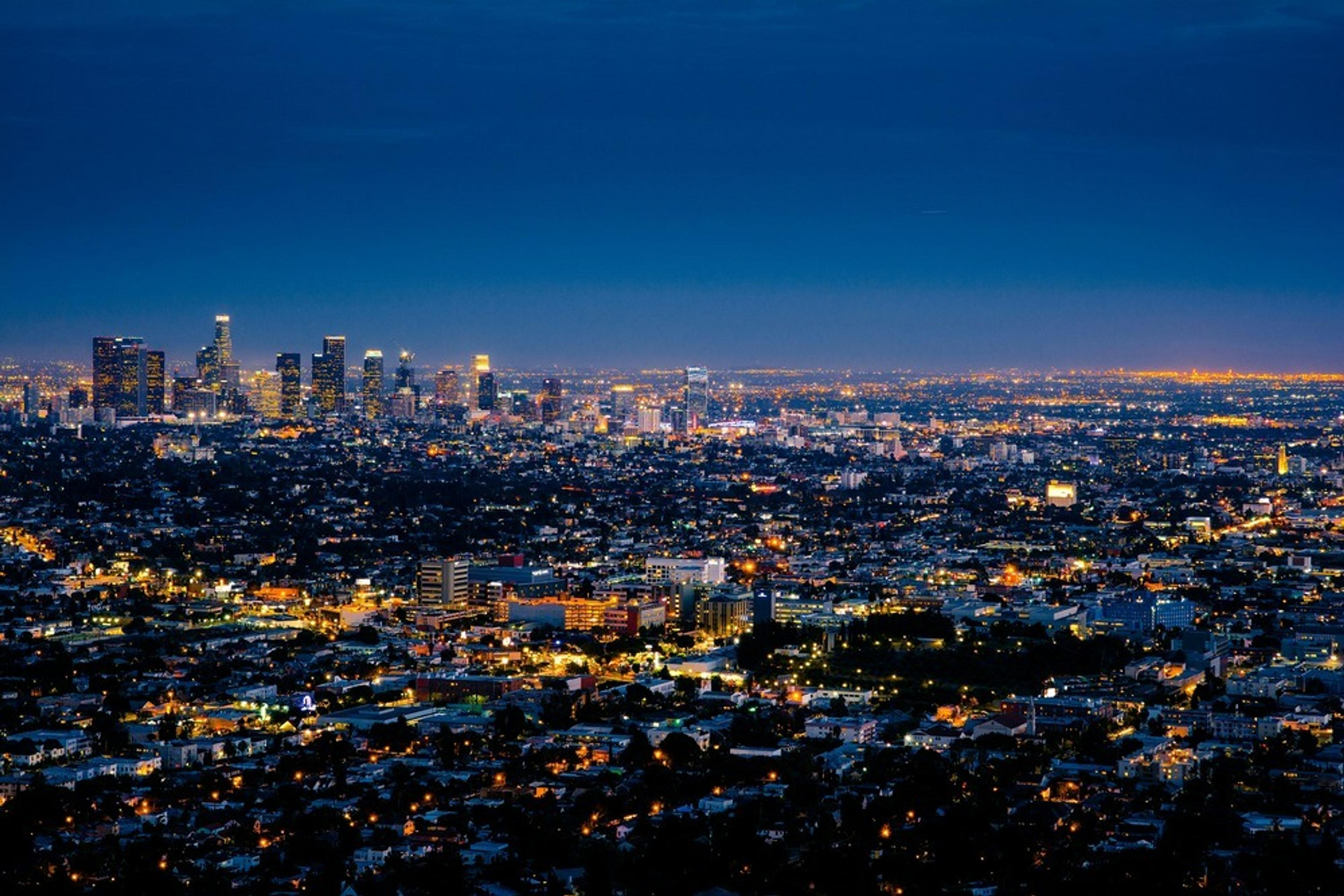A vibrant nighttime view of the Los Angeles cityscape with its iconic illuminated skyline.