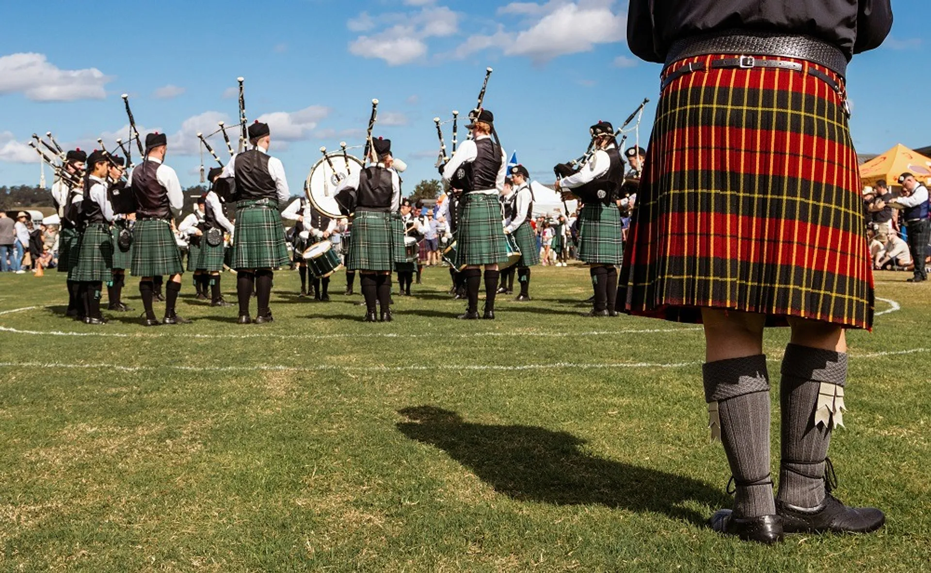 bagpipers in a field wearing kilts