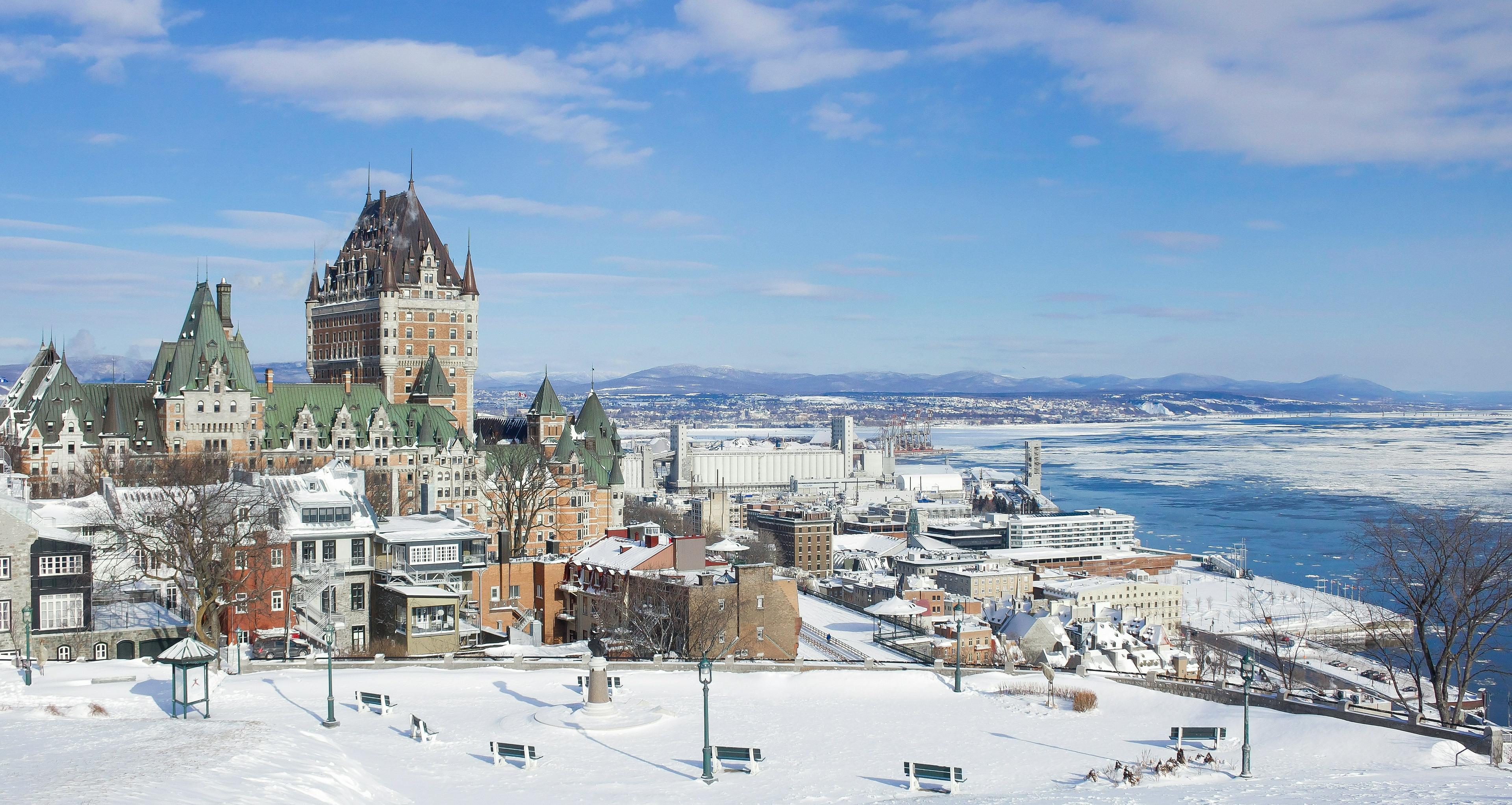 A winter view of Château Frontenac and the snowy landscape of Old Quebec City overlooking the St. Lawrence River.