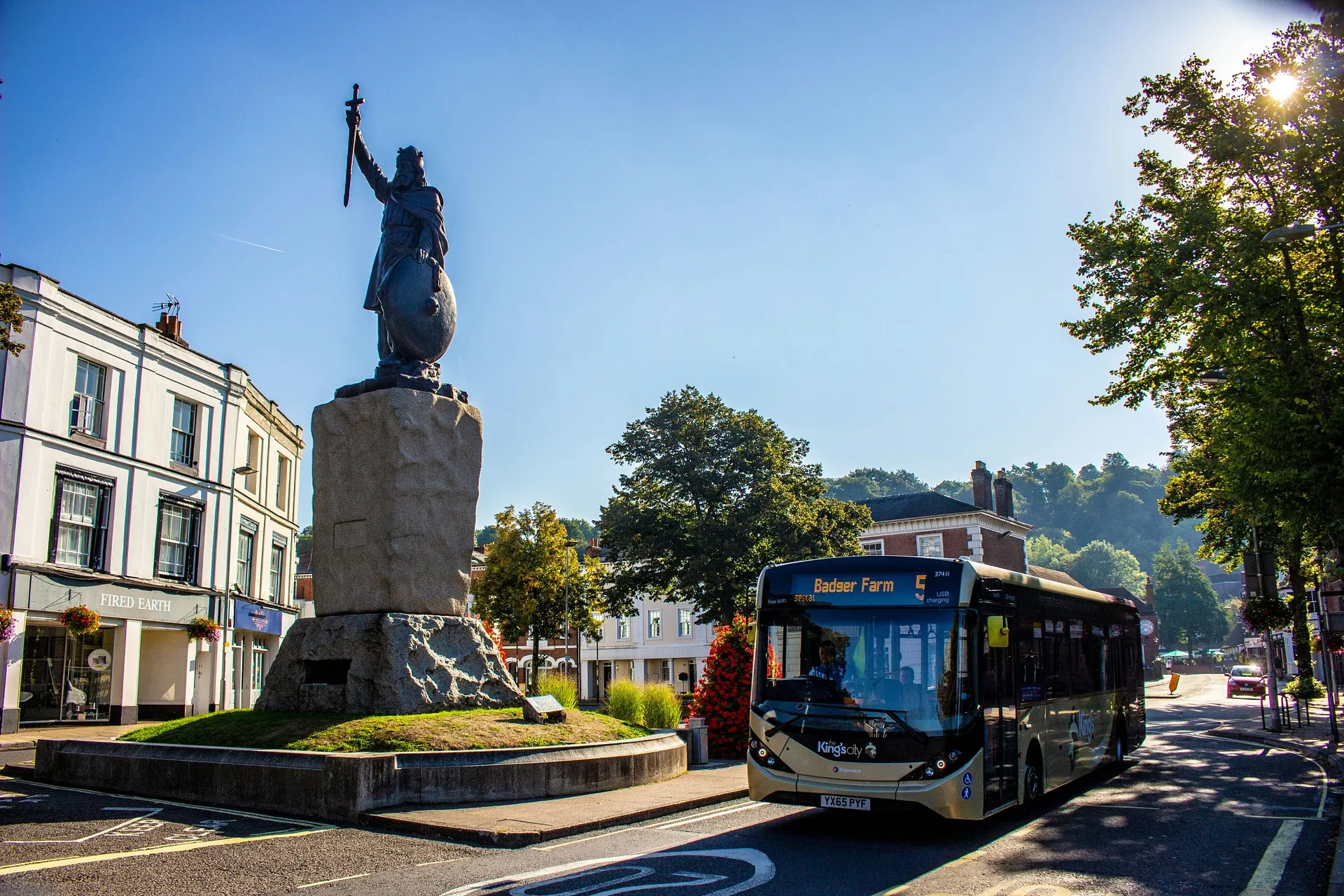 A bus passes beside the striking King Alfred's statue in Winchester, England.