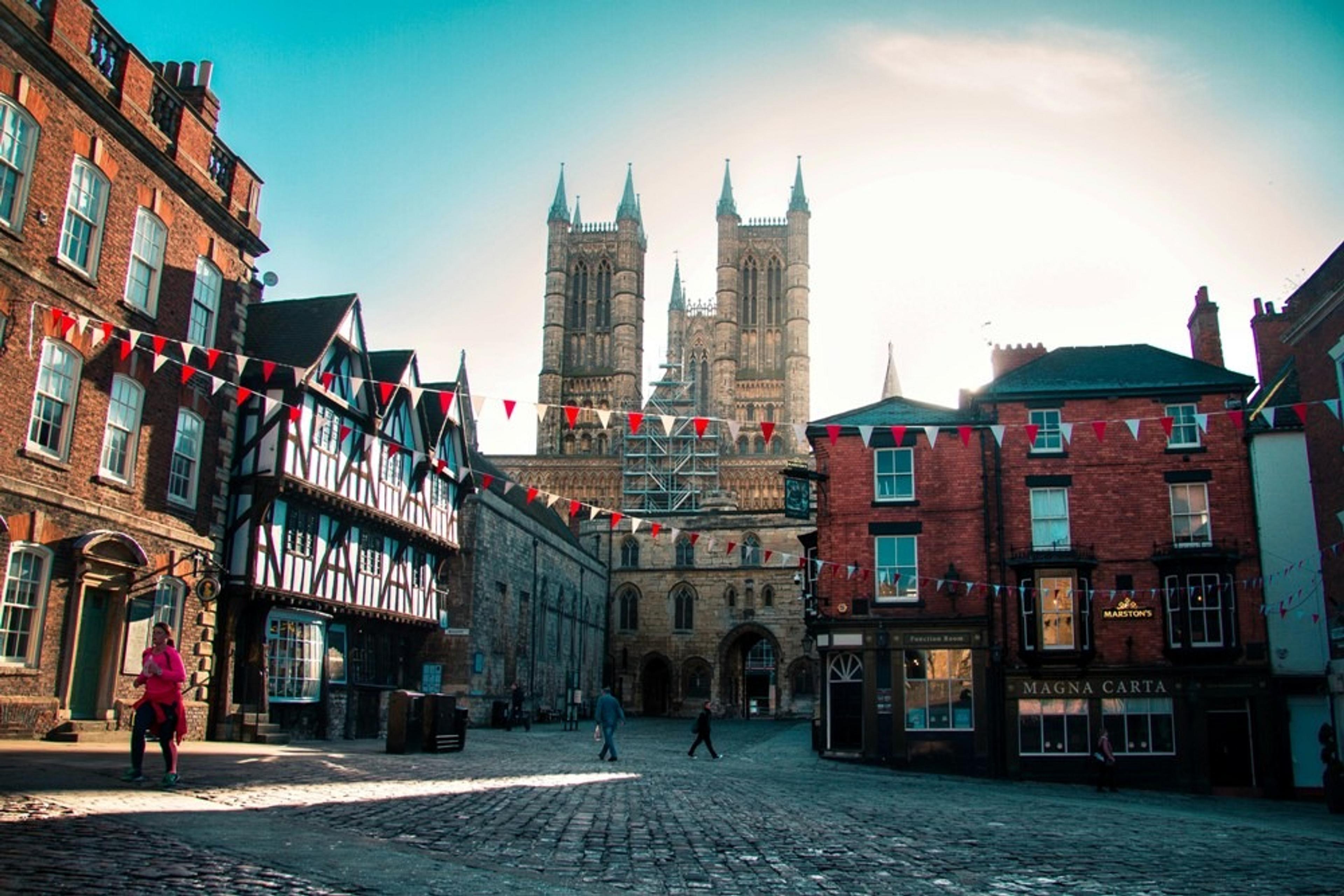 Twin spires of Lincoln Cathedral, a cobbled street with old buildings and bunting