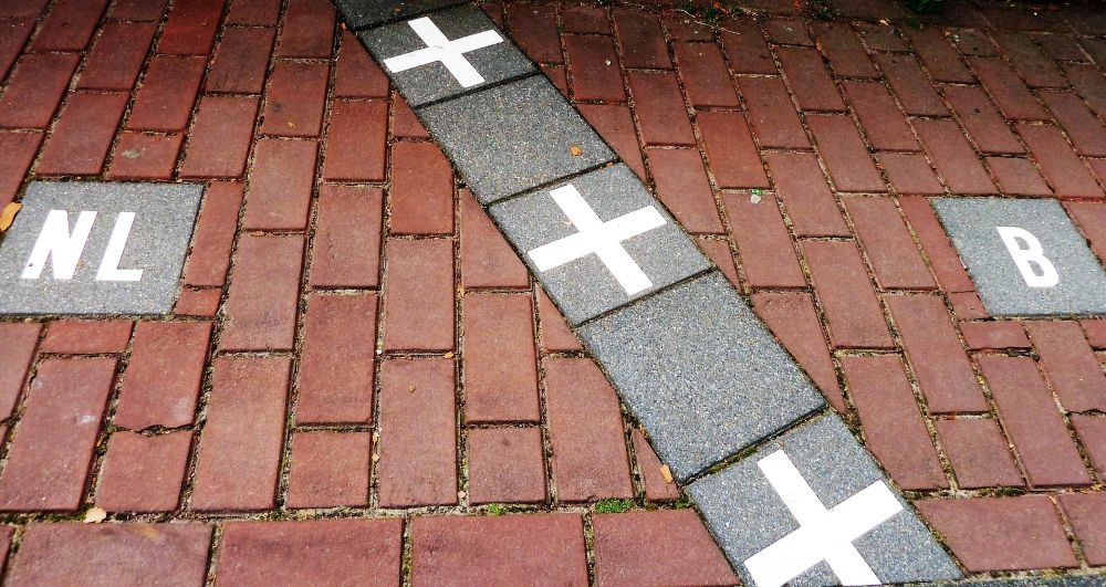 A line marking the border between the Netherlands and Belgium is displayed on a brick pathway in Baarle.