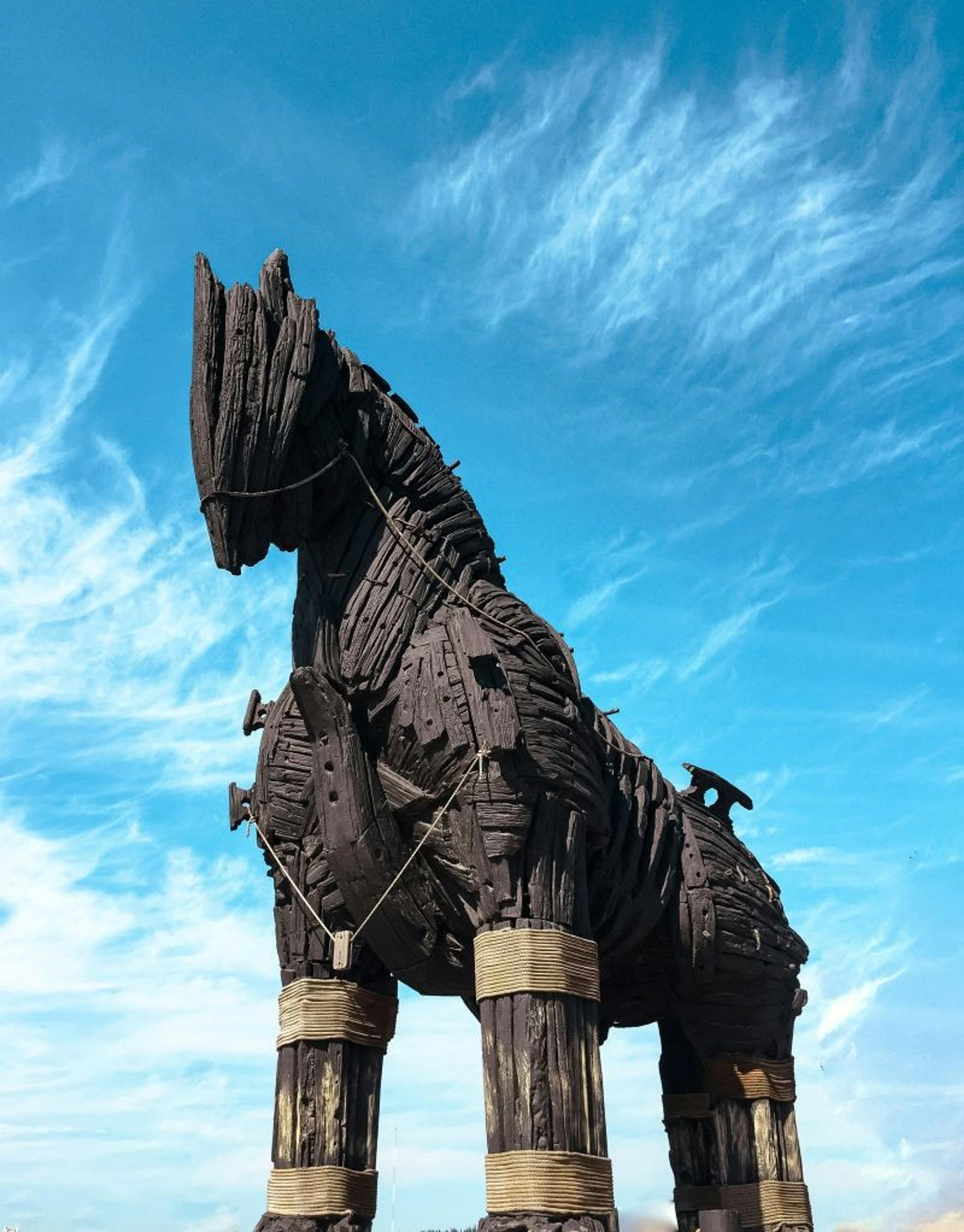 A large wooden structure resembling the Trojan Horse stands against a bright blue sky in Çanakkale, Turkey.
