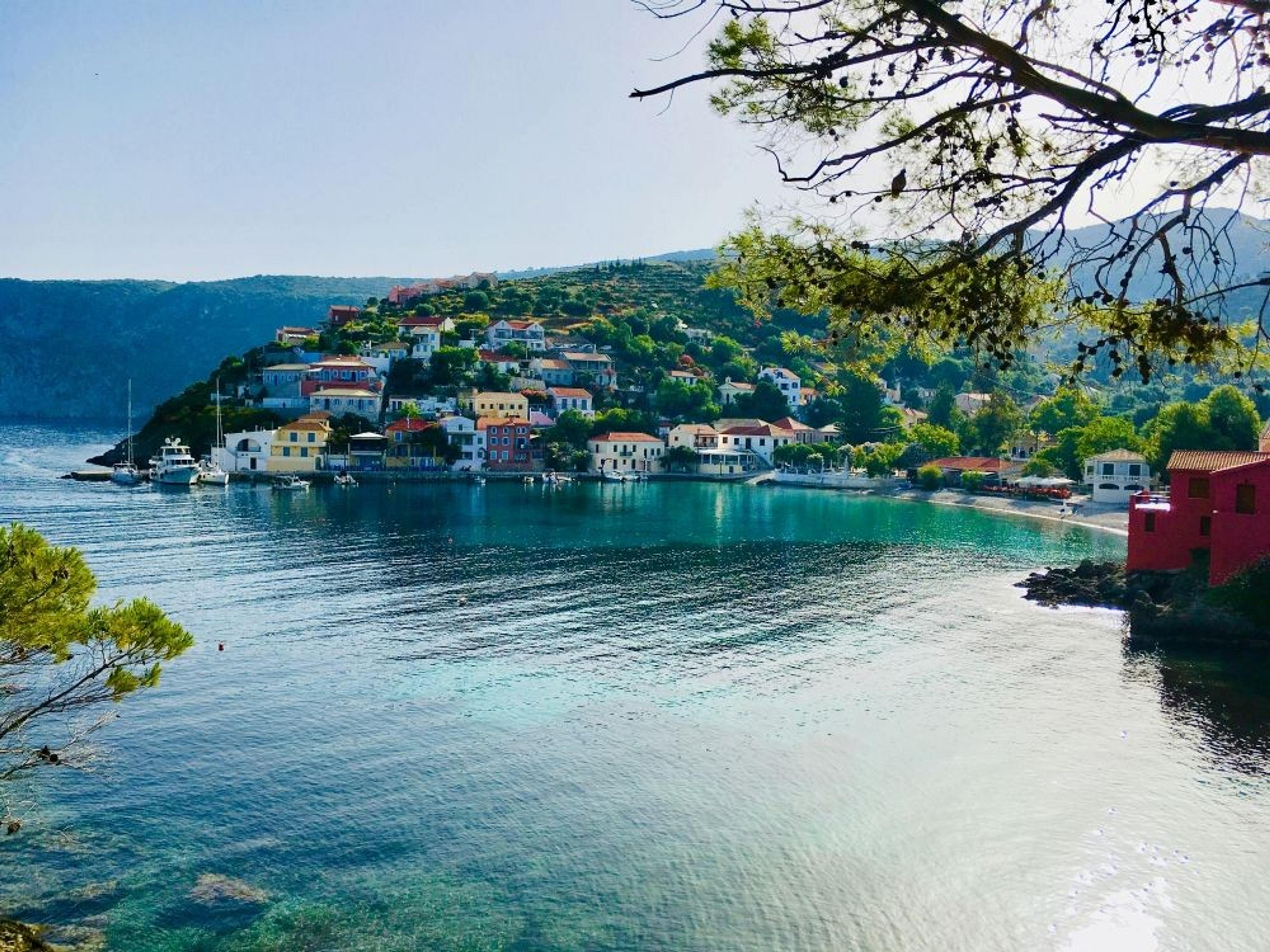 A picturesque view of the colorful village of Assos on the island of Kefalonia, Greece, nestled by a tranquil bay.
