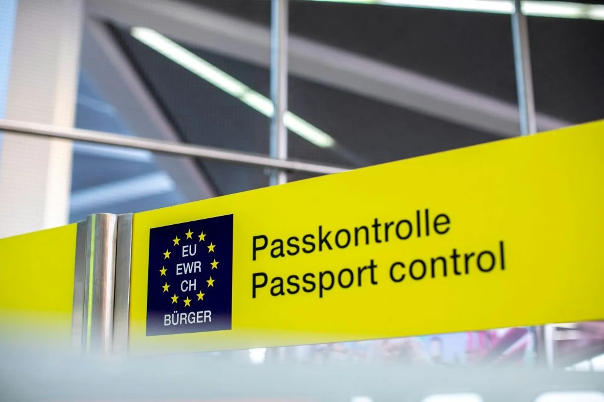 A yellow sign at passport control in a German-speaking airport.